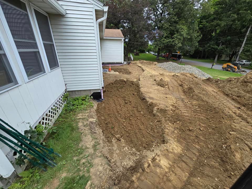 A large pile of dirt is in front of a house.