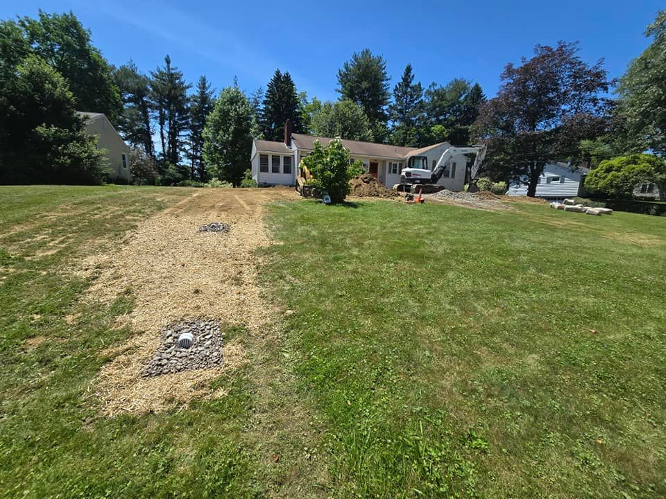 A house is sitting in the middle of a lush green field.