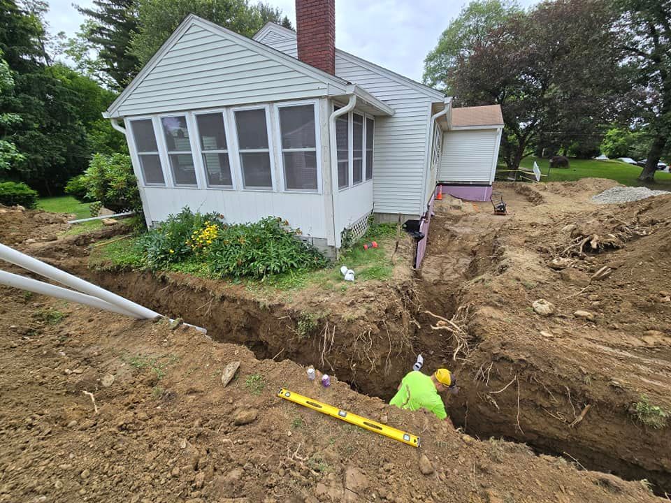 A man is digging a hole in front of a house.