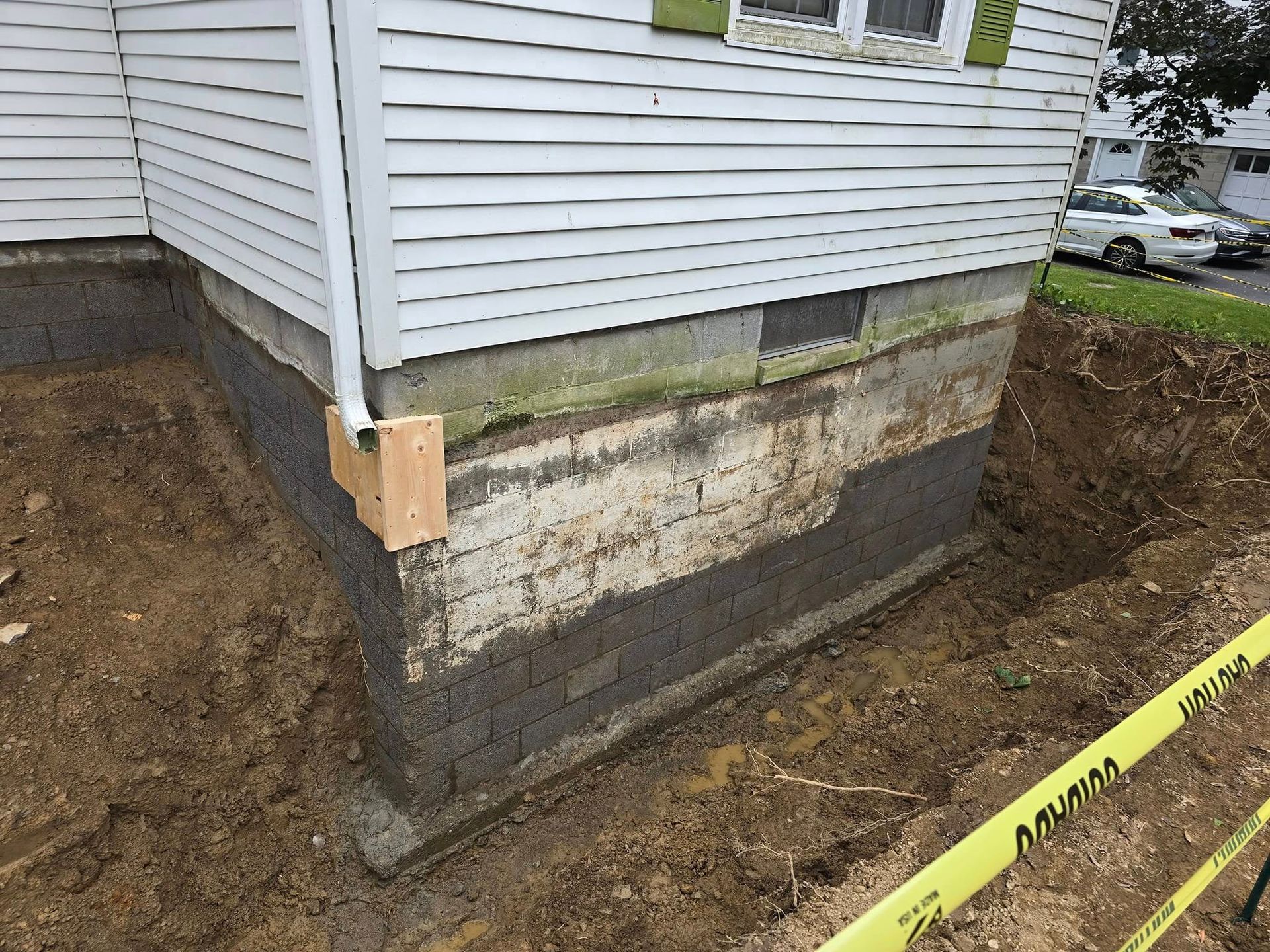 A house with a hole in the ground in front of it.