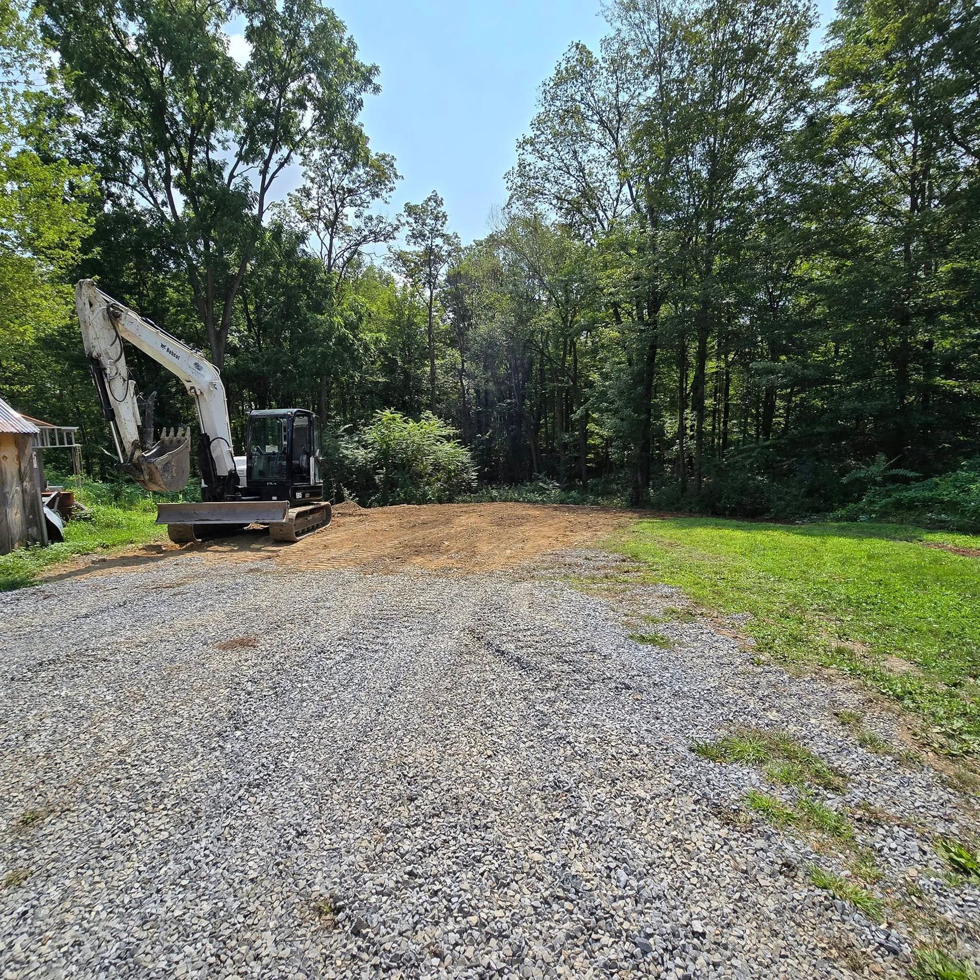 A bulldozer is sitting in the middle of a gravel road.
