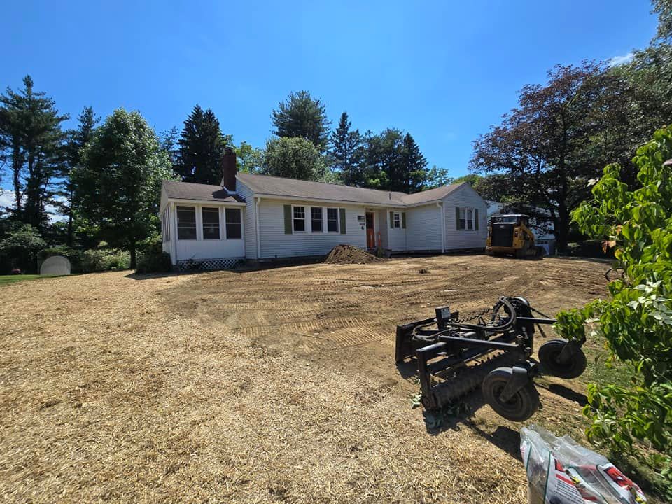 A white house is sitting on top of a dirt field.