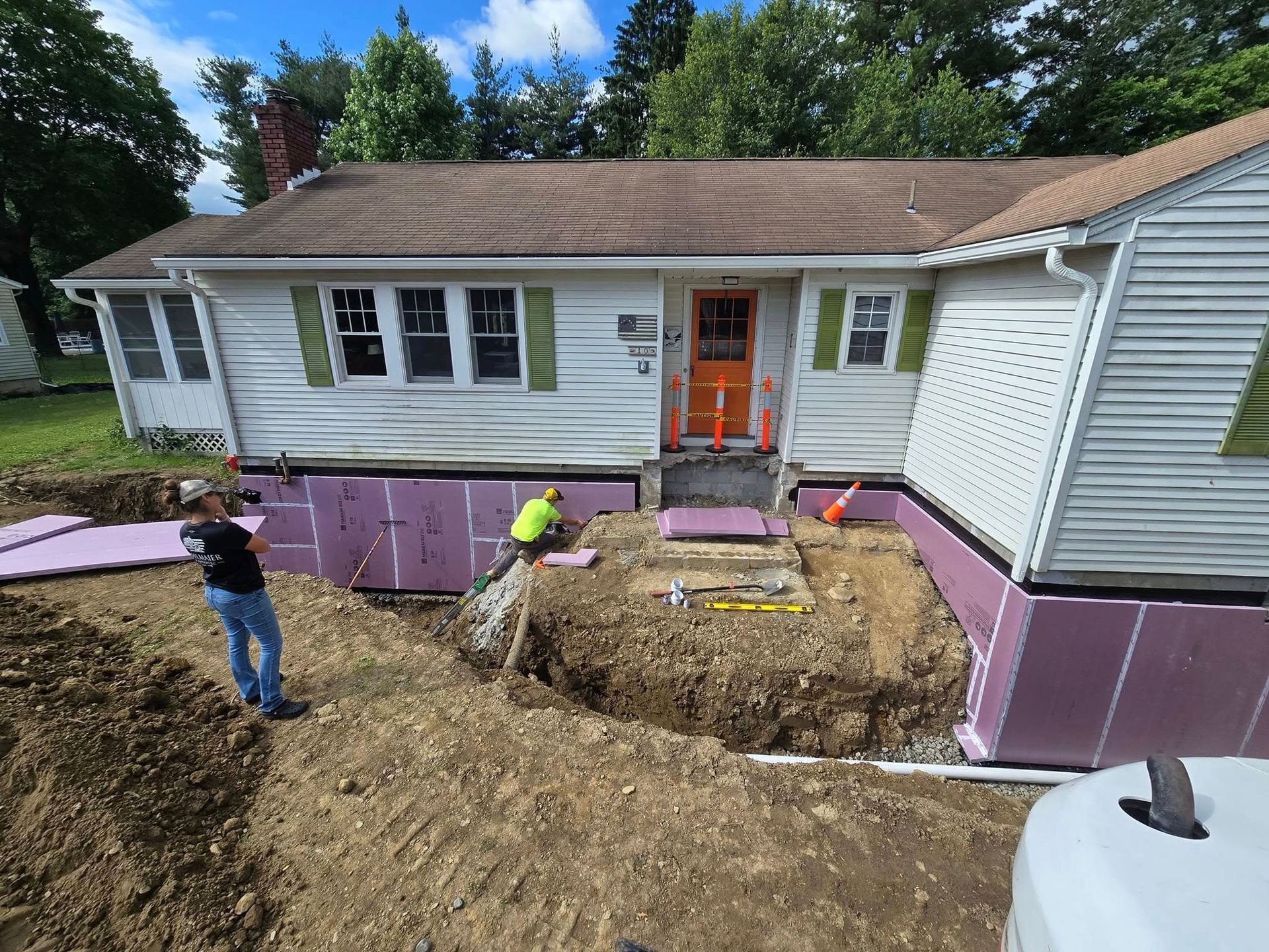 A man is standing in front of a house that is being remodeled.