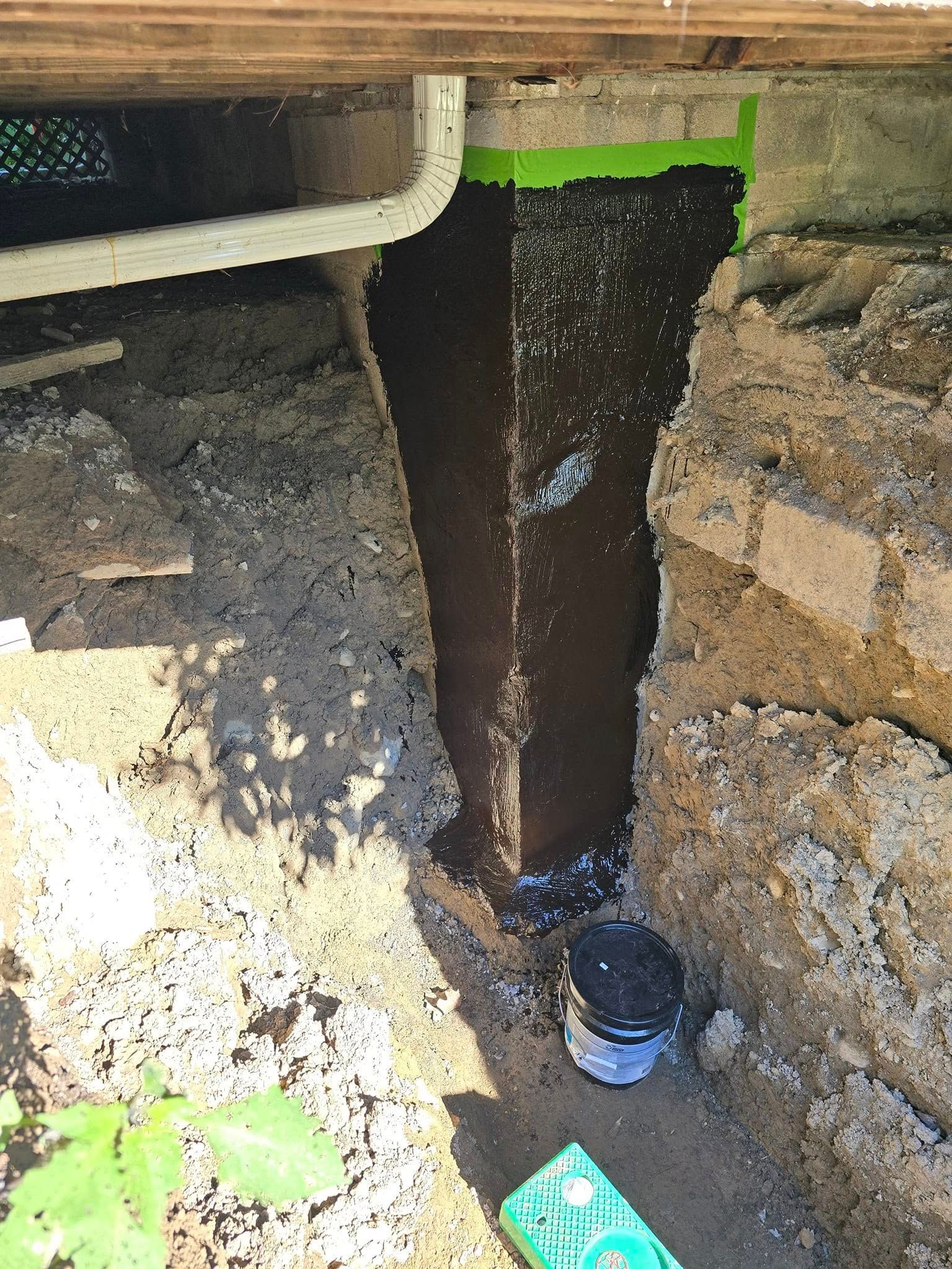 A drain pipe is being installed under a wooden deck.