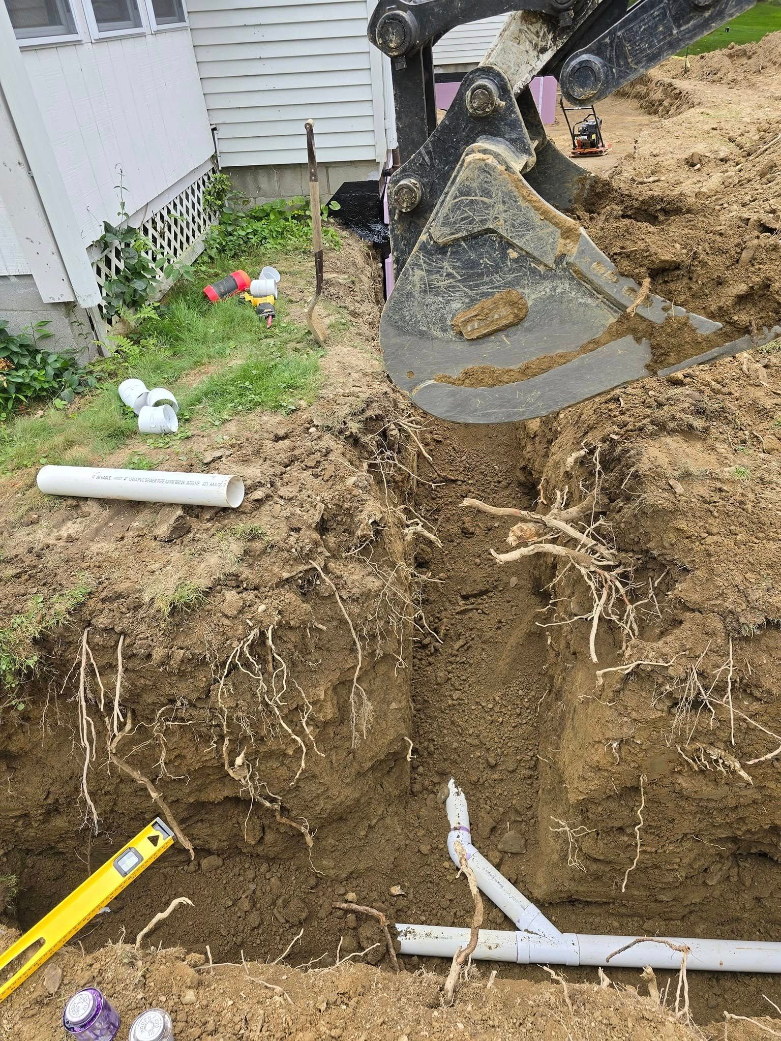 A person is digging a hole in the ground next to a house.