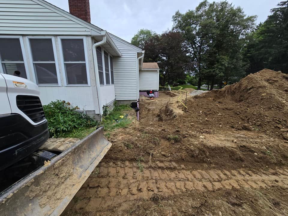 A bulldozer is moving dirt in front of a house.