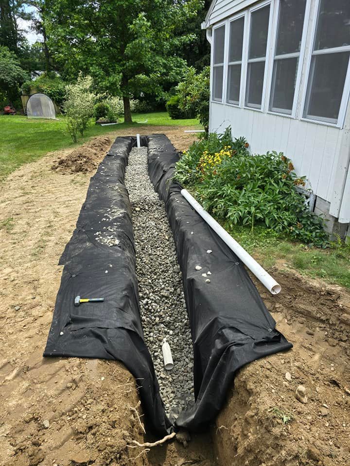 A drainage system is being installed in front of a house.