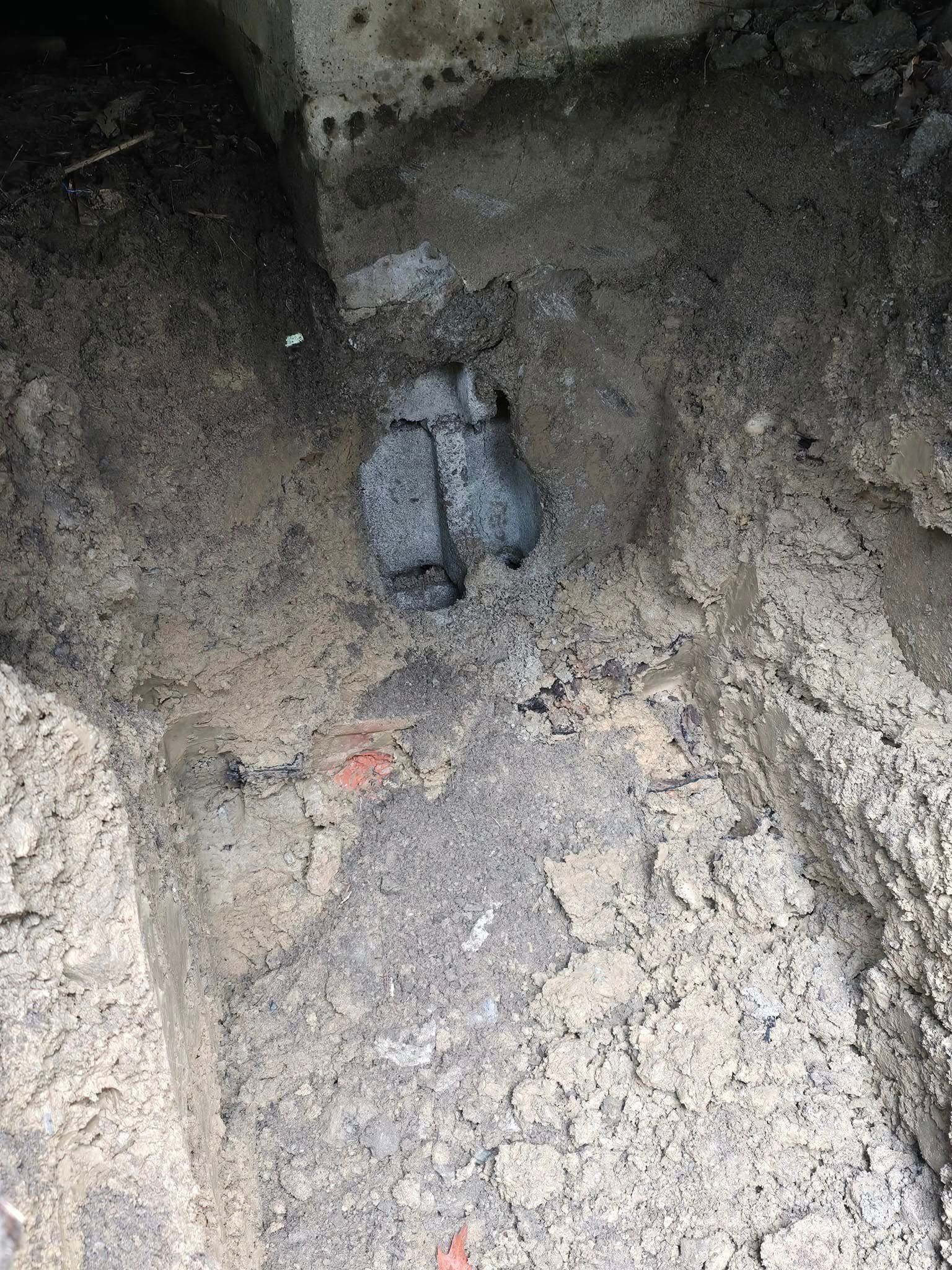 A close up of a hole in the ground with a pipe in it.