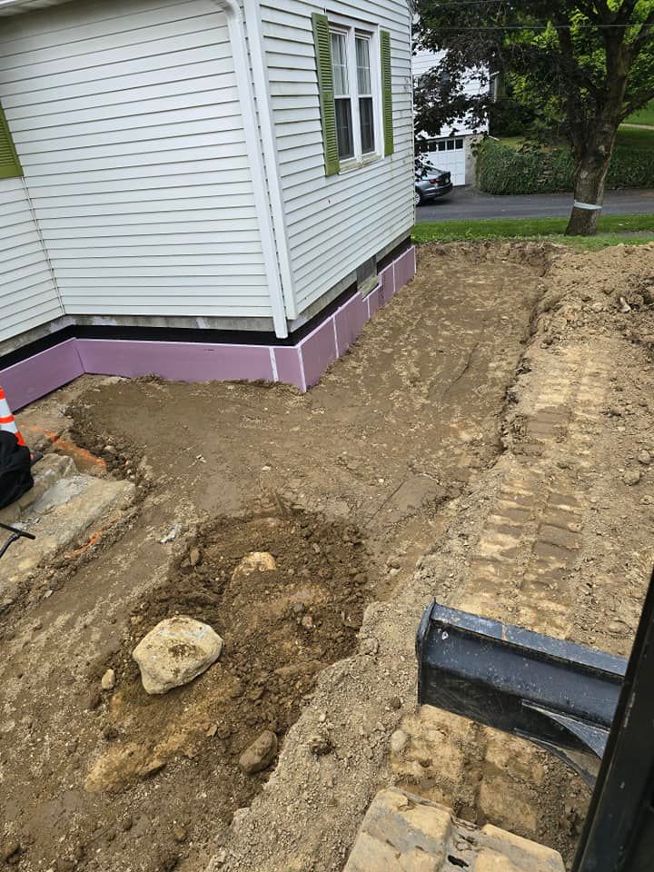 A man is digging a hole in the dirt in front of a house.