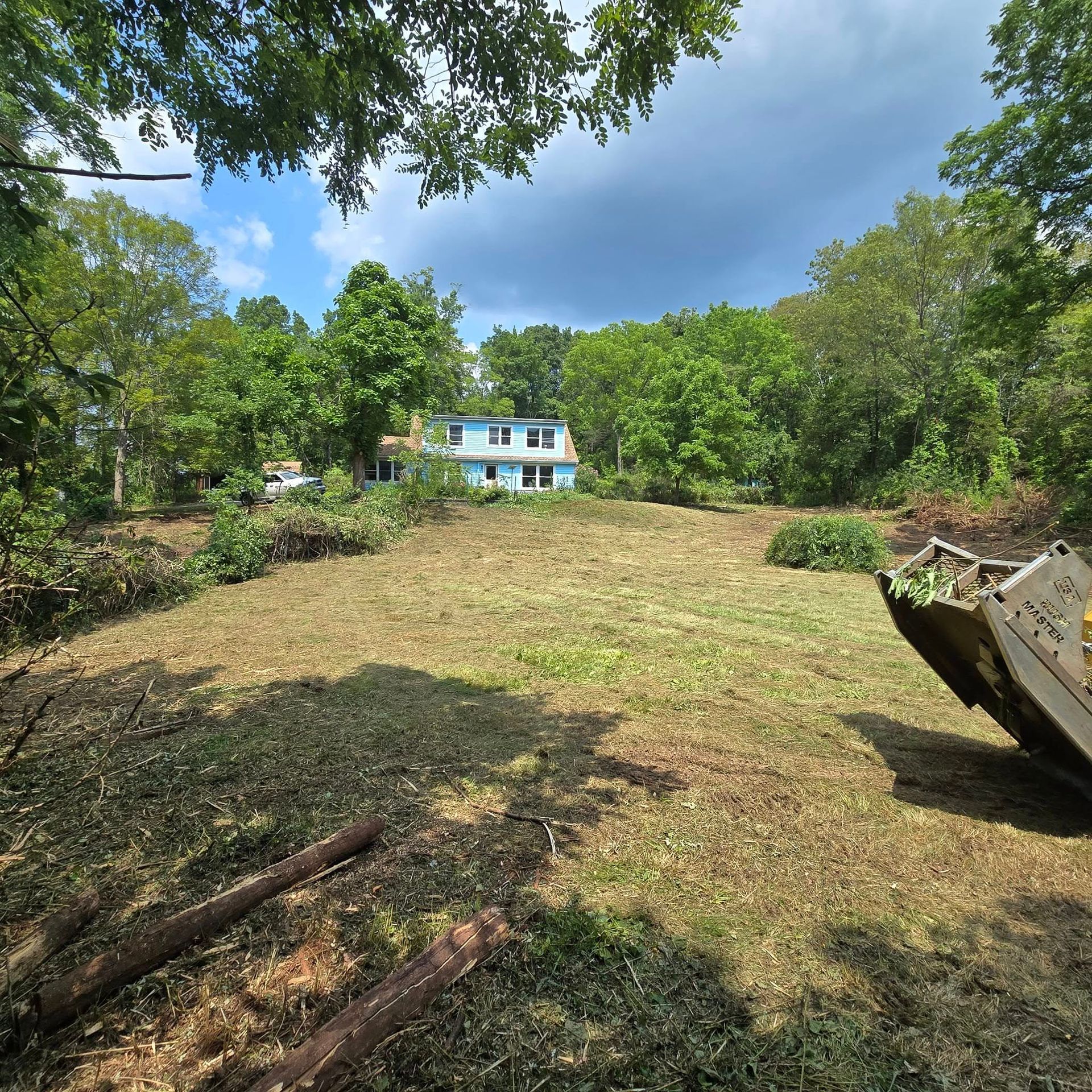 A large grassy field with a house in the background