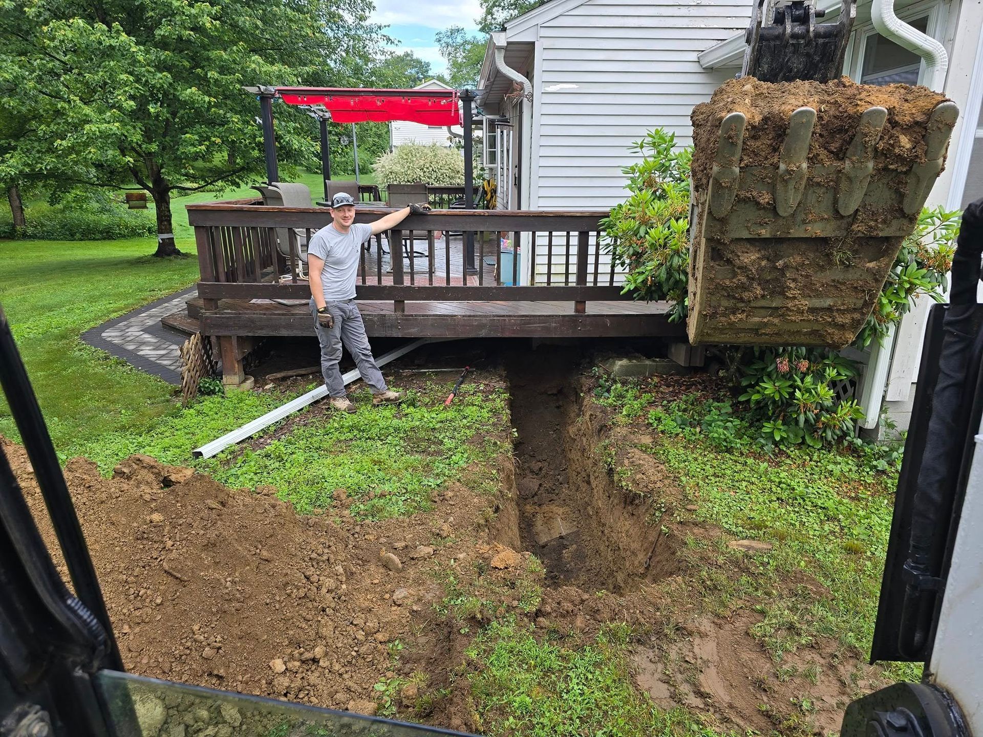 A man is standing in the dirt in front of a house.
