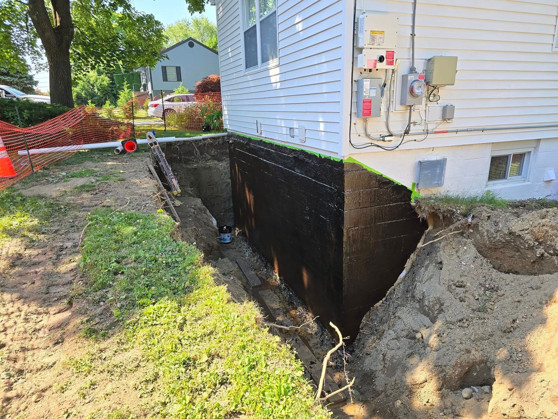 A house with a hole in the ground in front of it.
