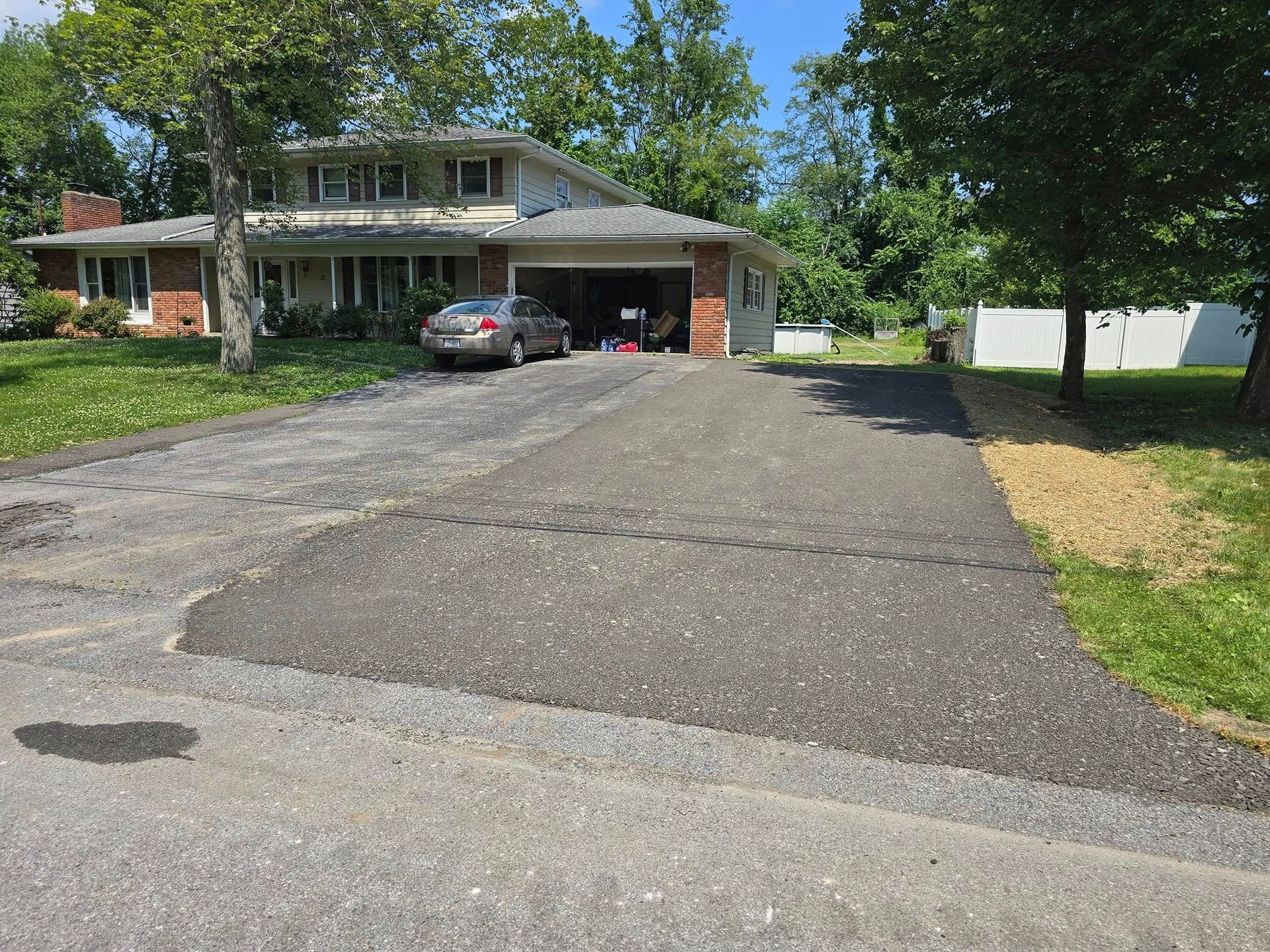 A car is parked in a driveway in front of a house.