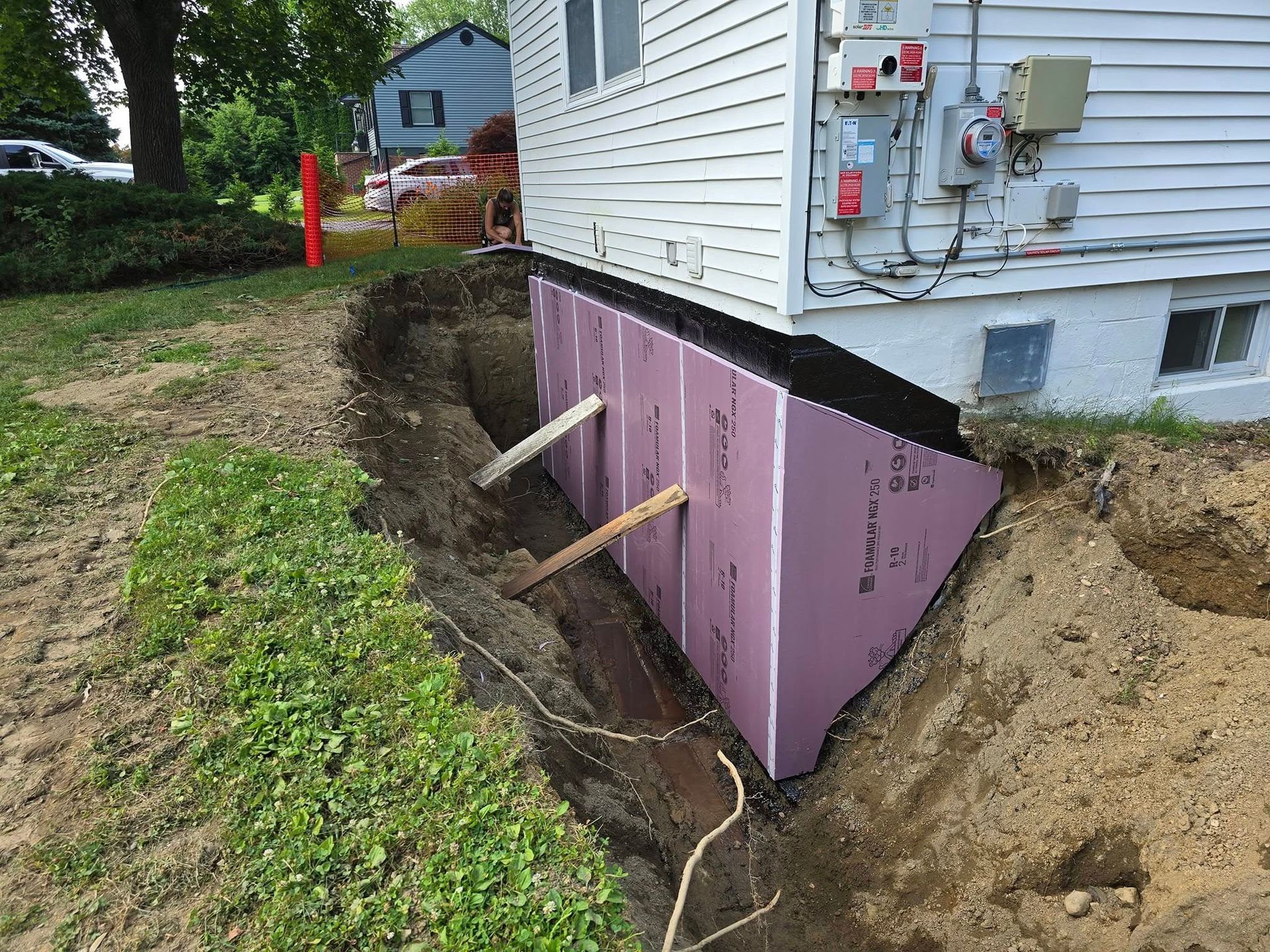 A house with a hole in the ground in front of it.