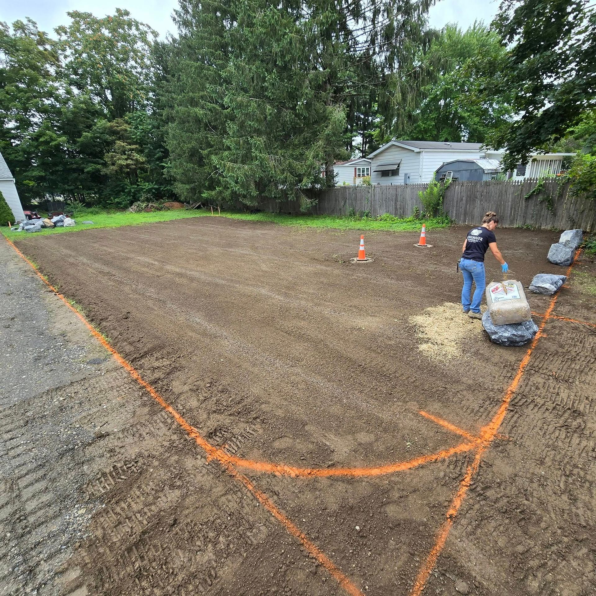 A man is standing in the middle of a dirt field.