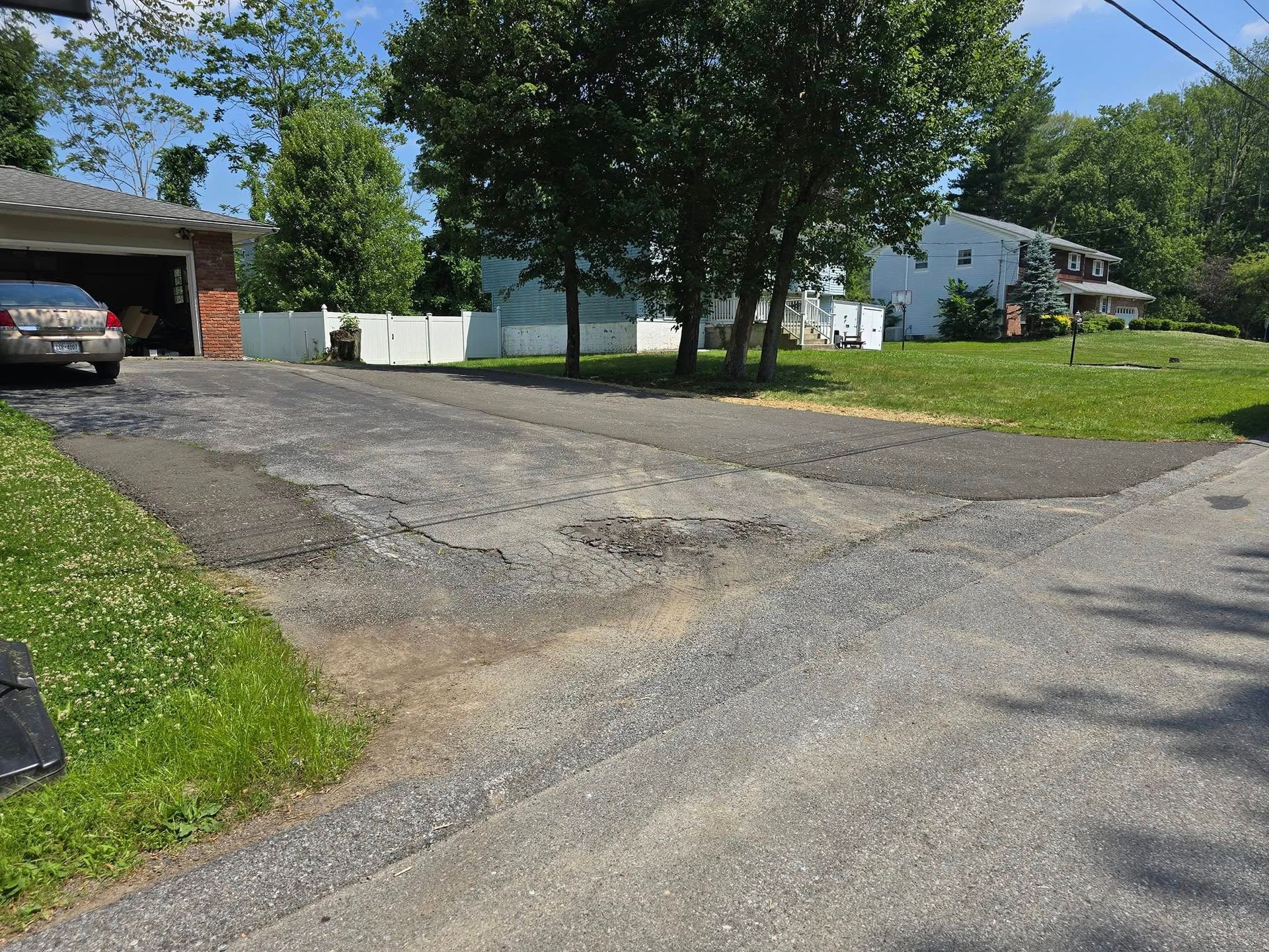 A car is parked in a driveway next to a house.