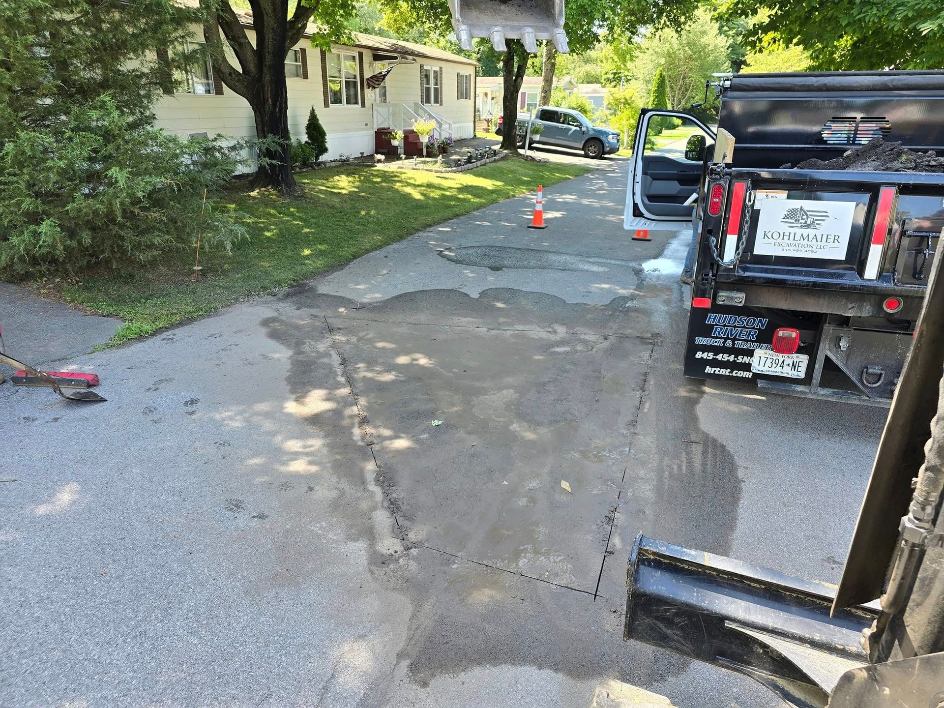 A truck is parked on the side of the road next to a house.