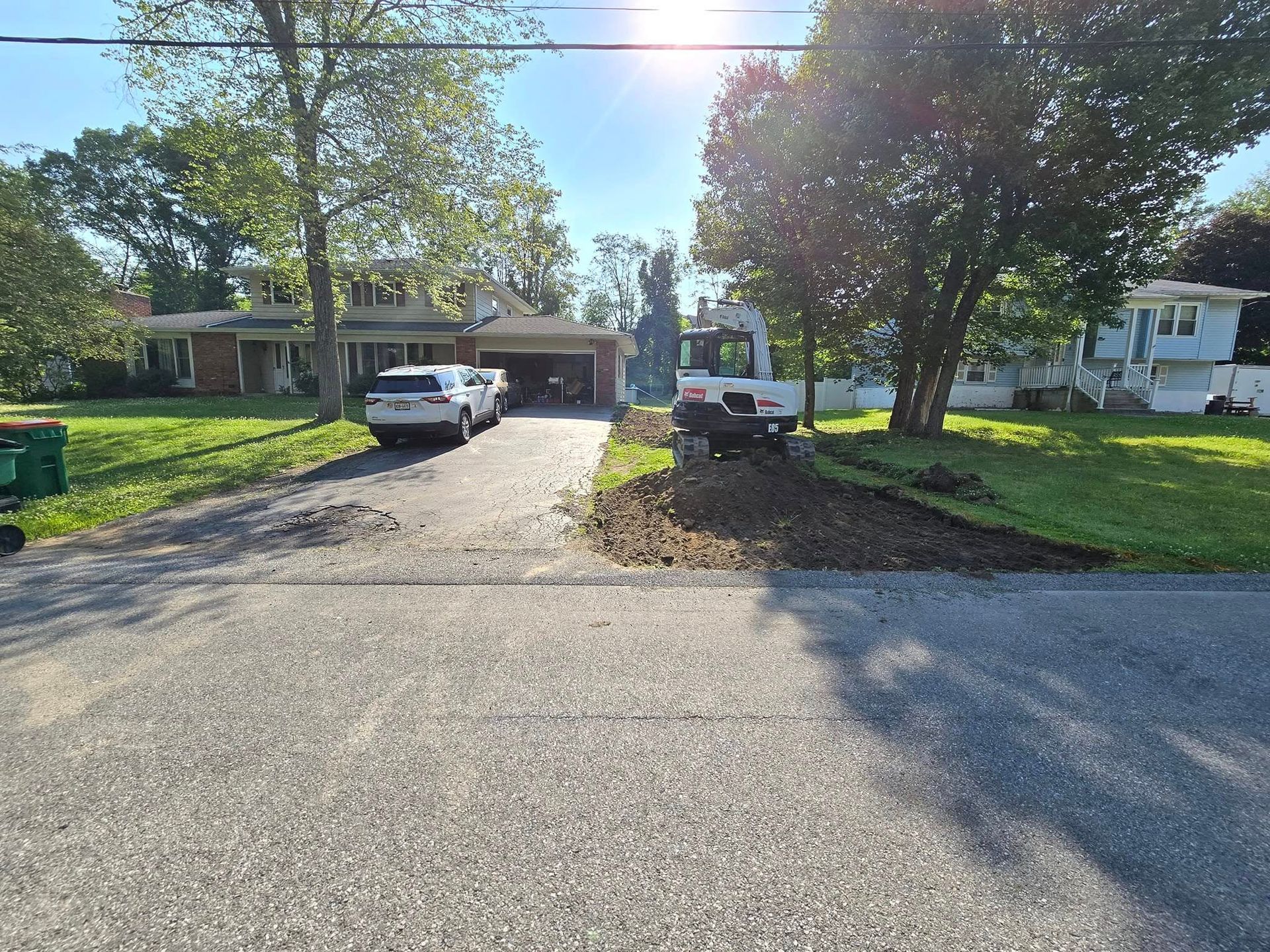 A car is parked in a driveway next to a house.