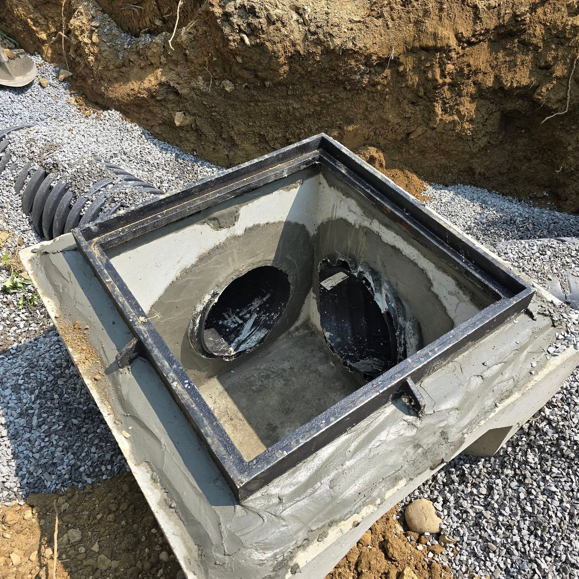 A manhole cover is sitting on top of a pile of gravel.