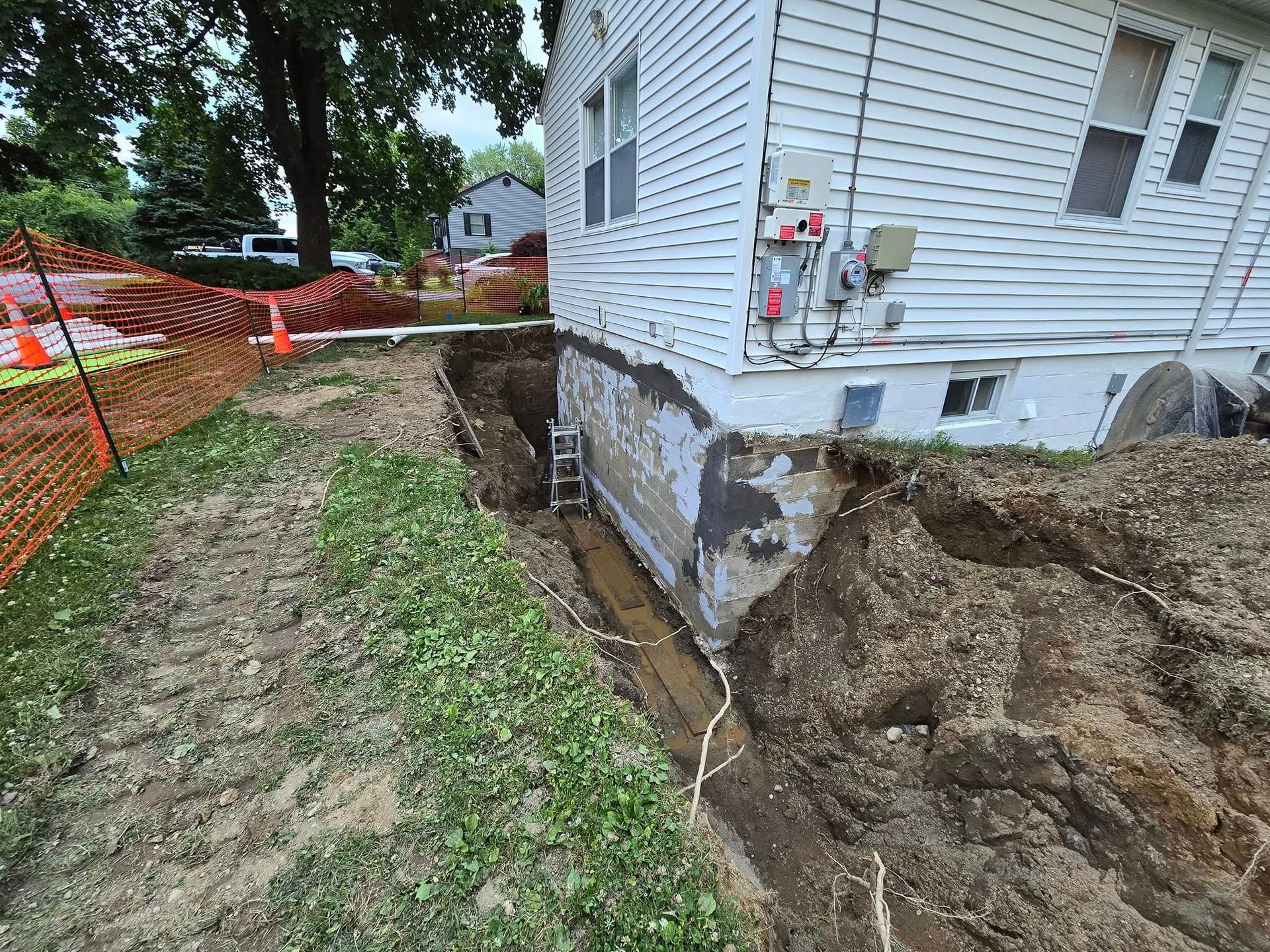 A house with a hole in the ground in front of it.