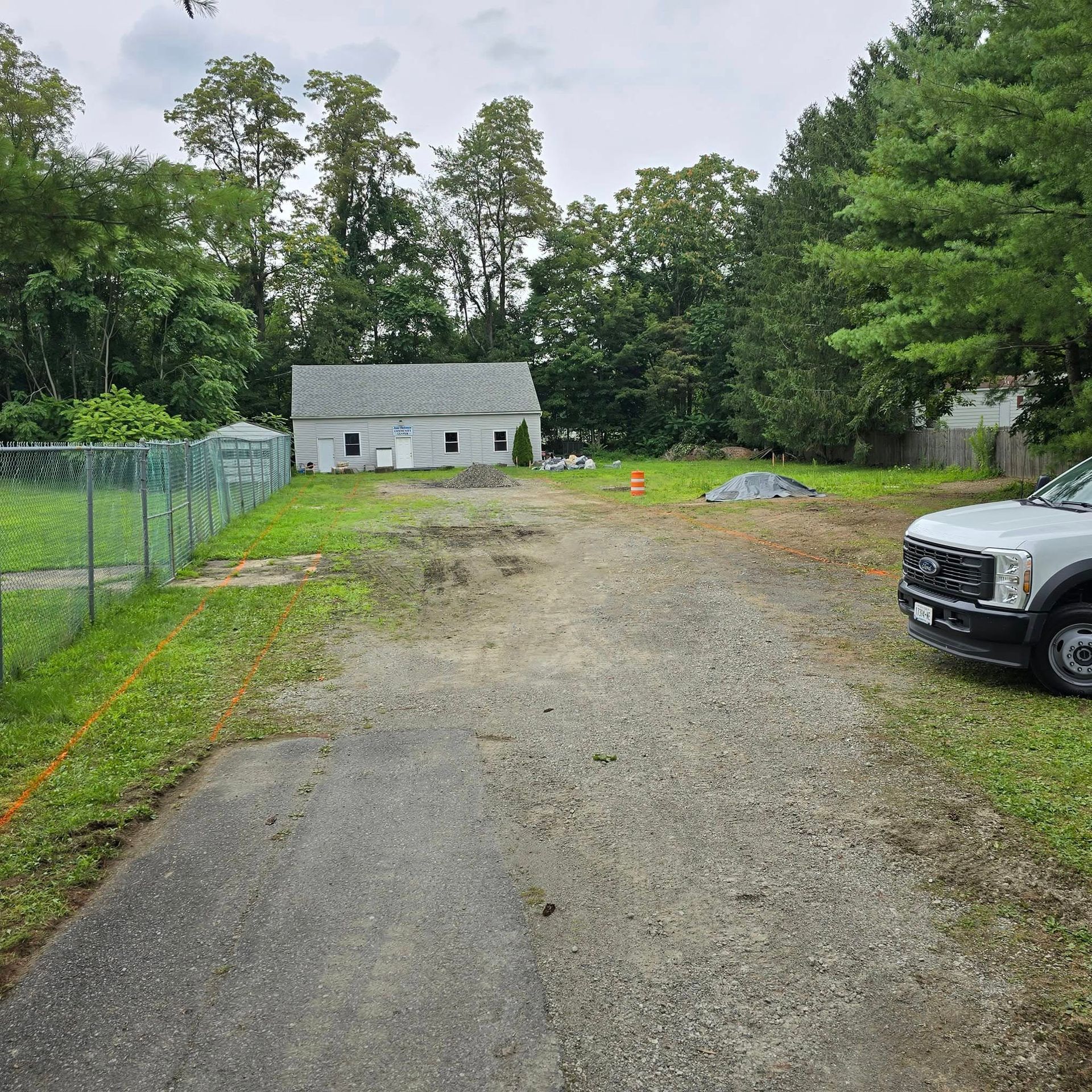 A white truck is parked on the side of a dirt road