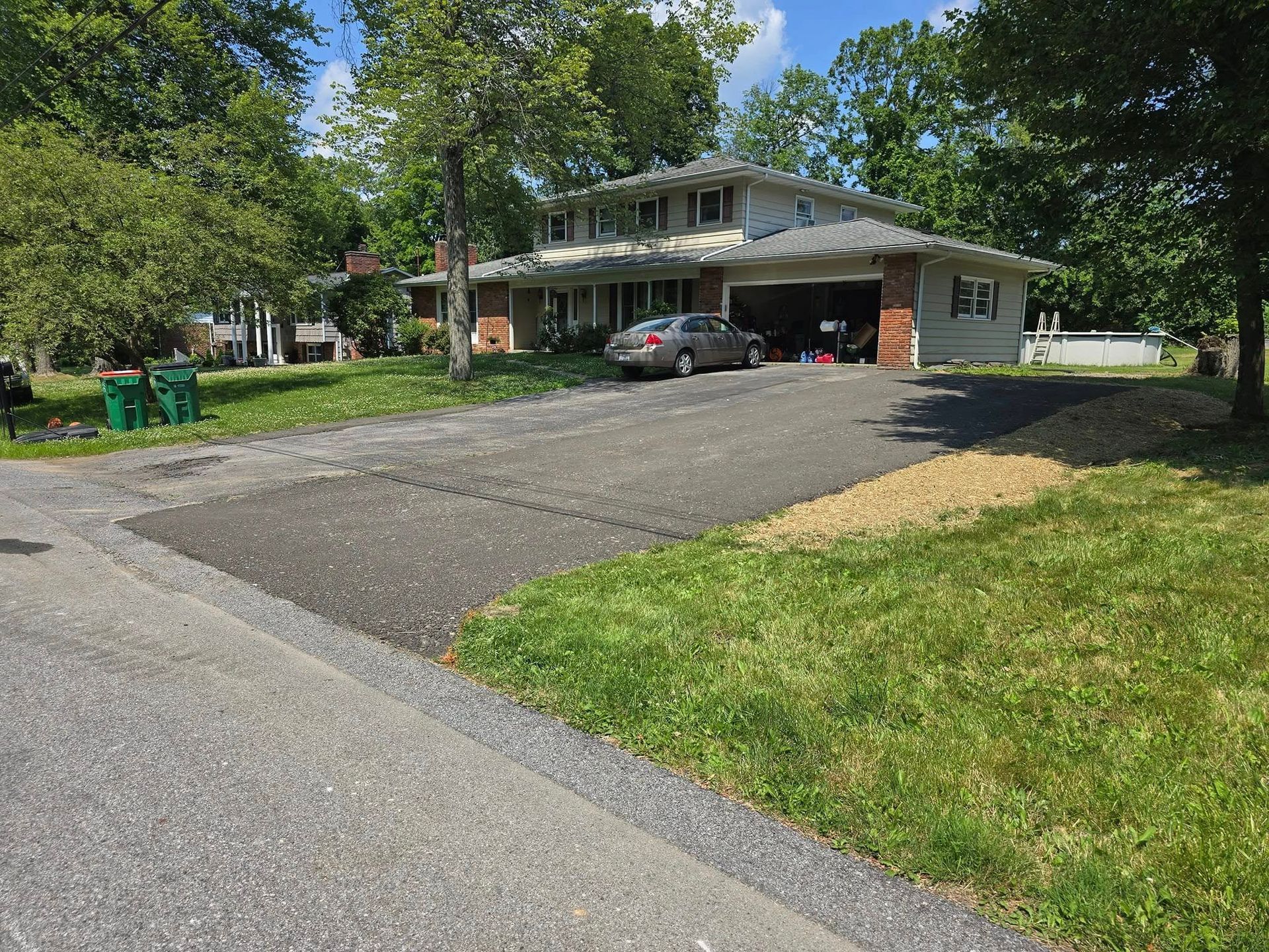A car is parked in a driveway in front of a house.