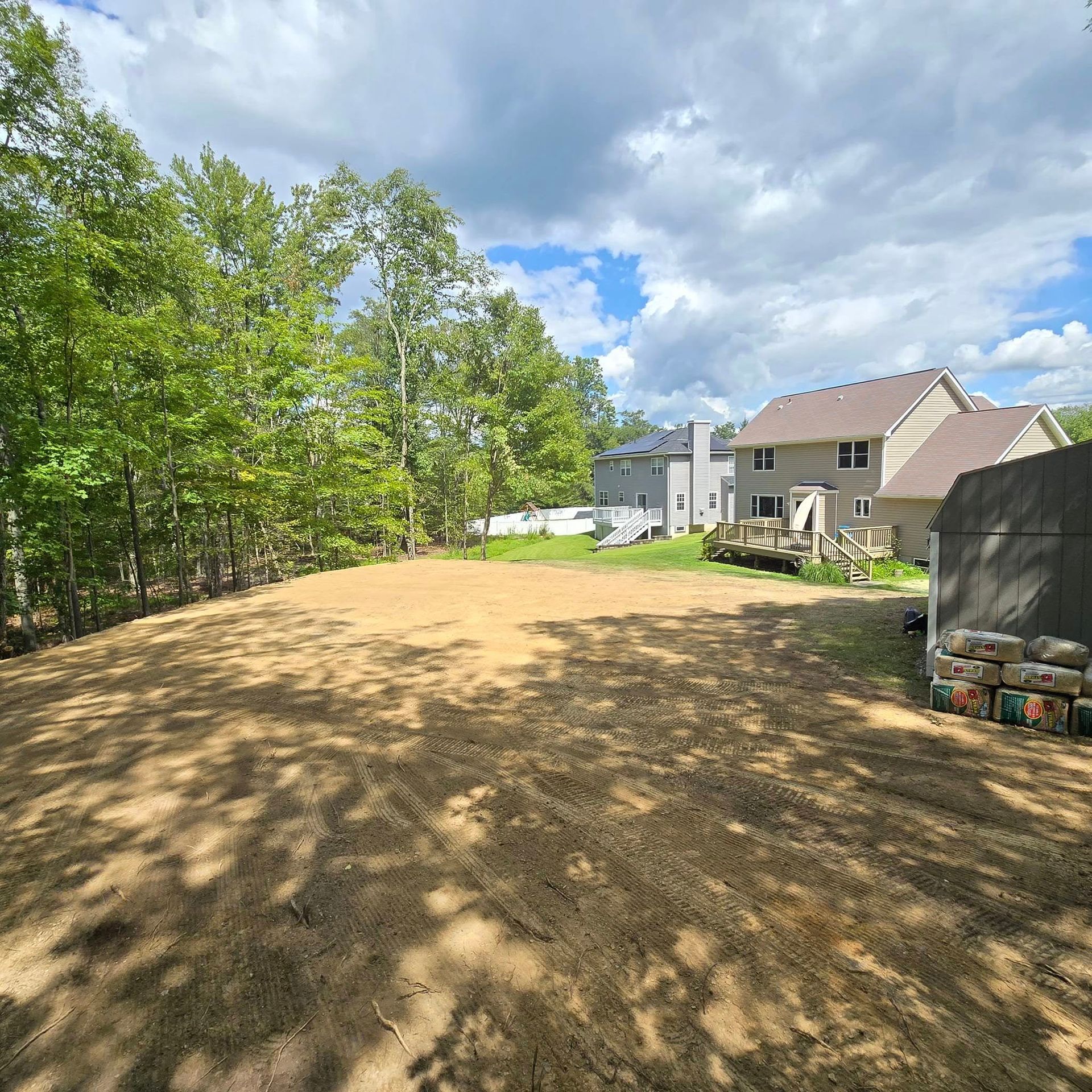 A large dirt field with a house in the background