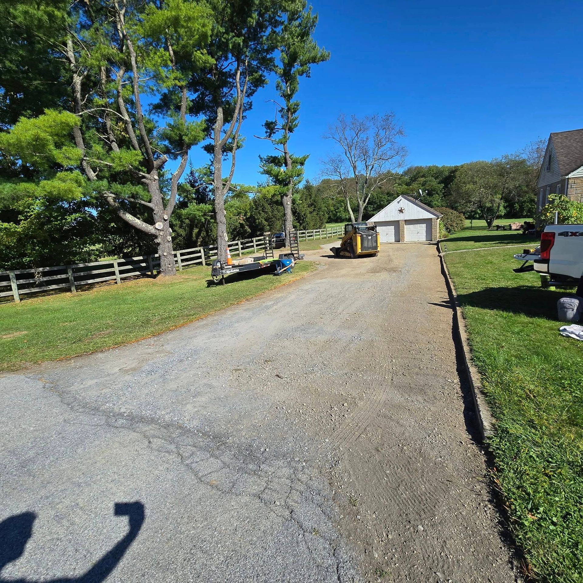 A truck is parked on the side of a gravel road