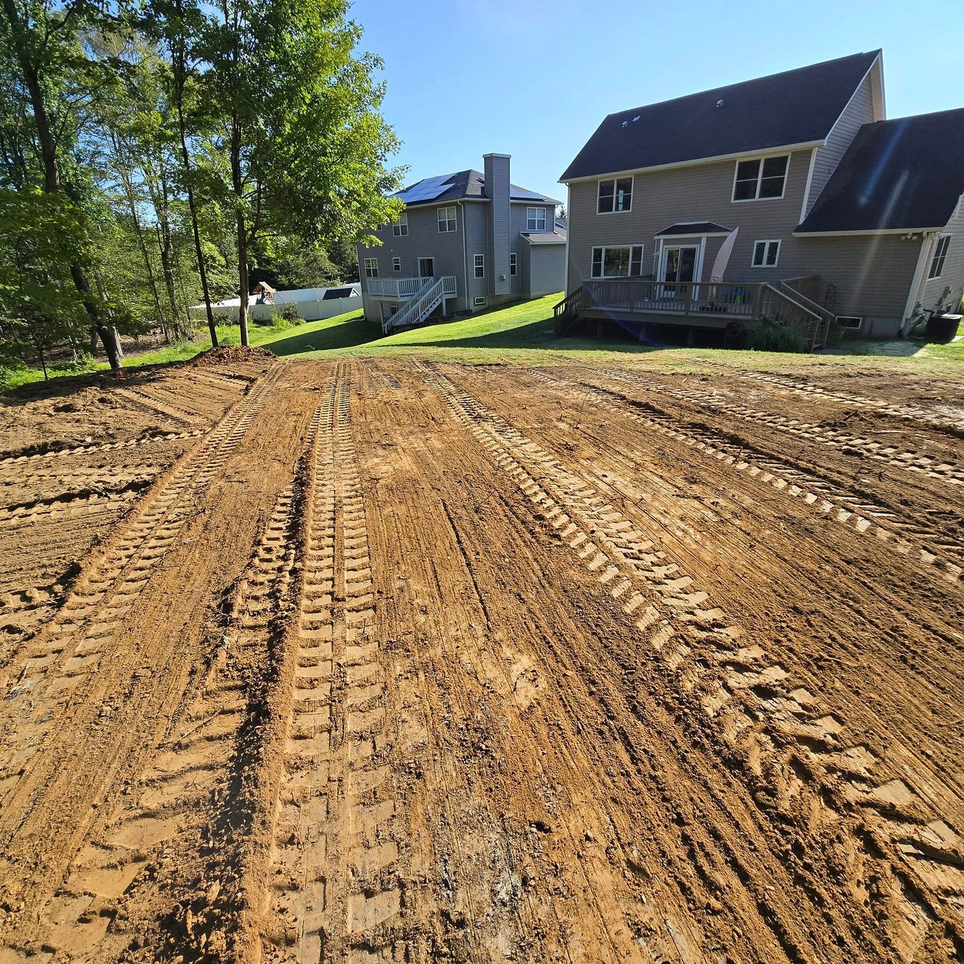 A dirt road with a house in the background
