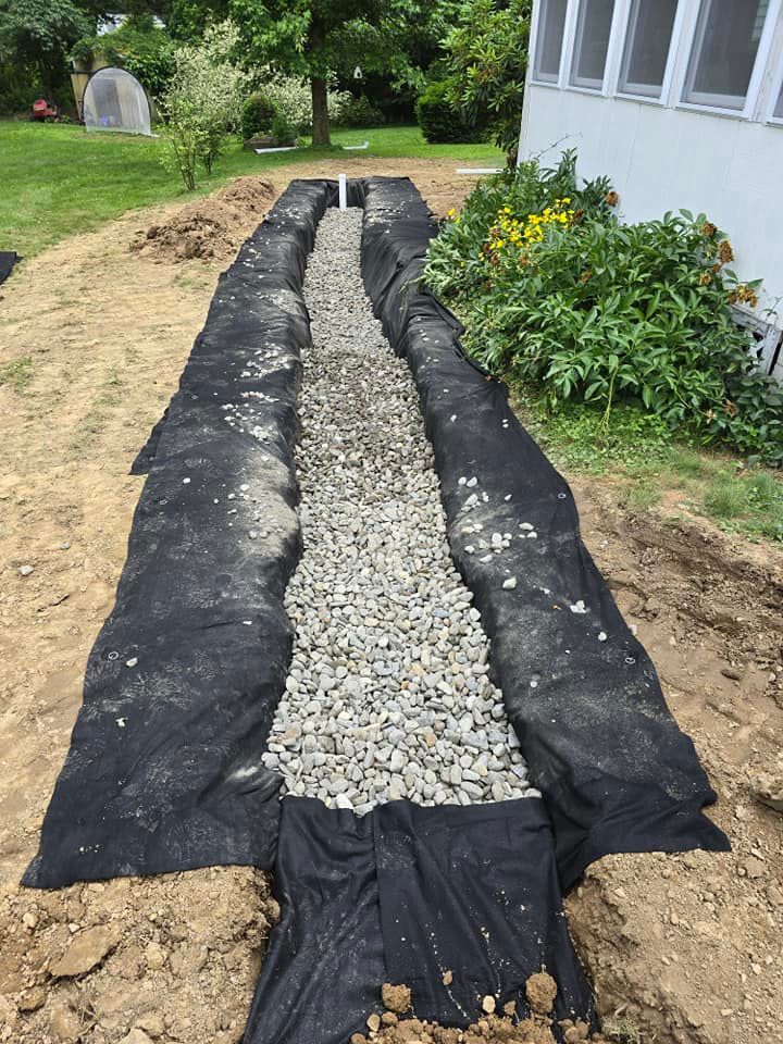 A drainage system is being built in the backyard of a house.