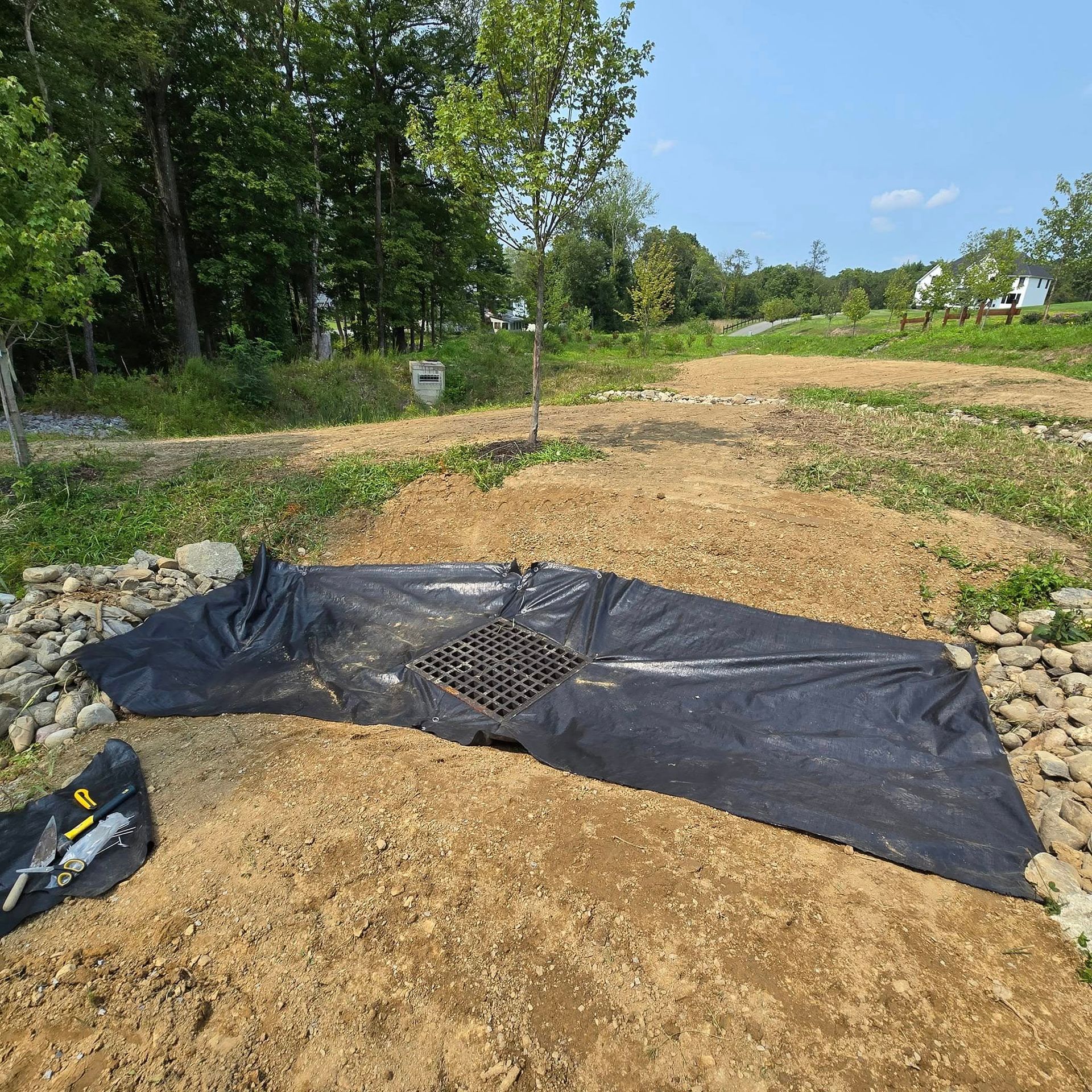A black tarp is laying on top of a pile of dirt.