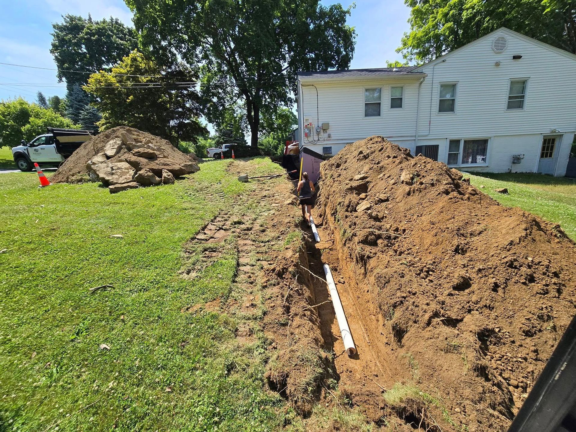 A large pile of dirt is sitting in front of a house.