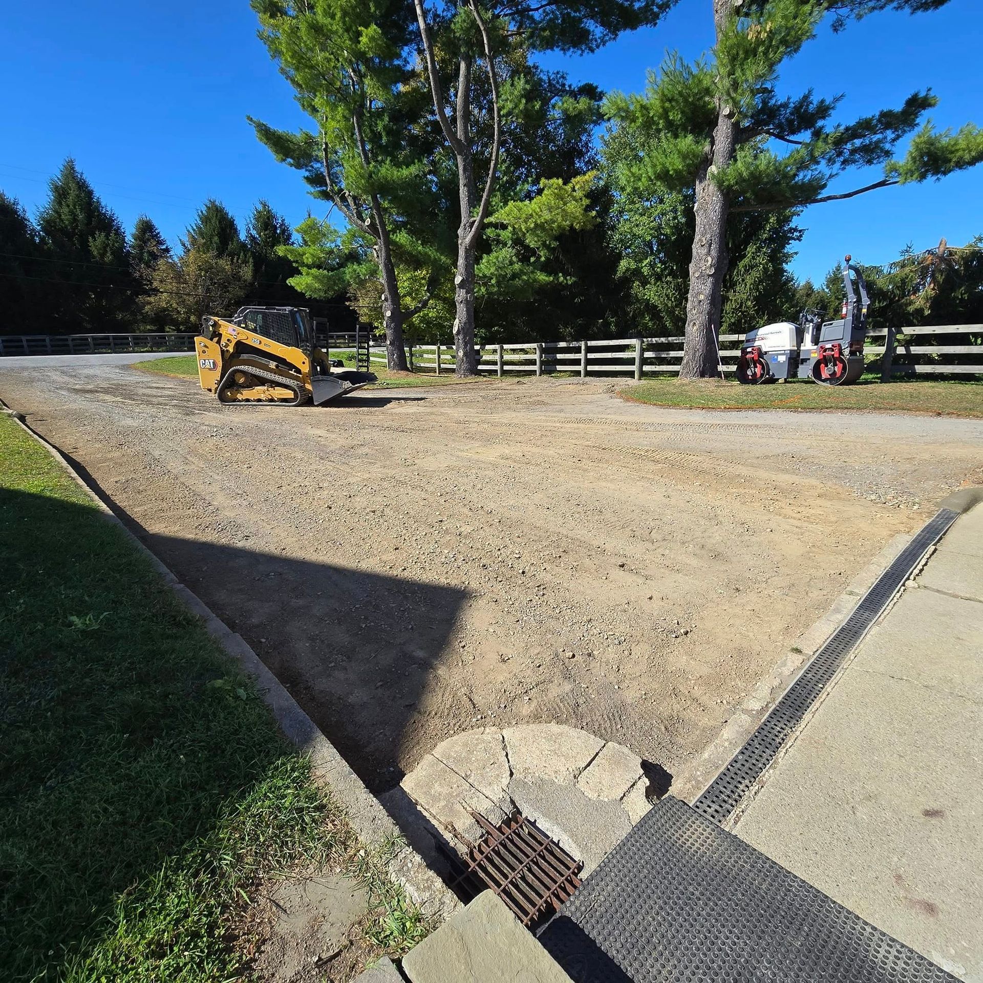 A yellow bulldozer is parked on the side of a dirt road