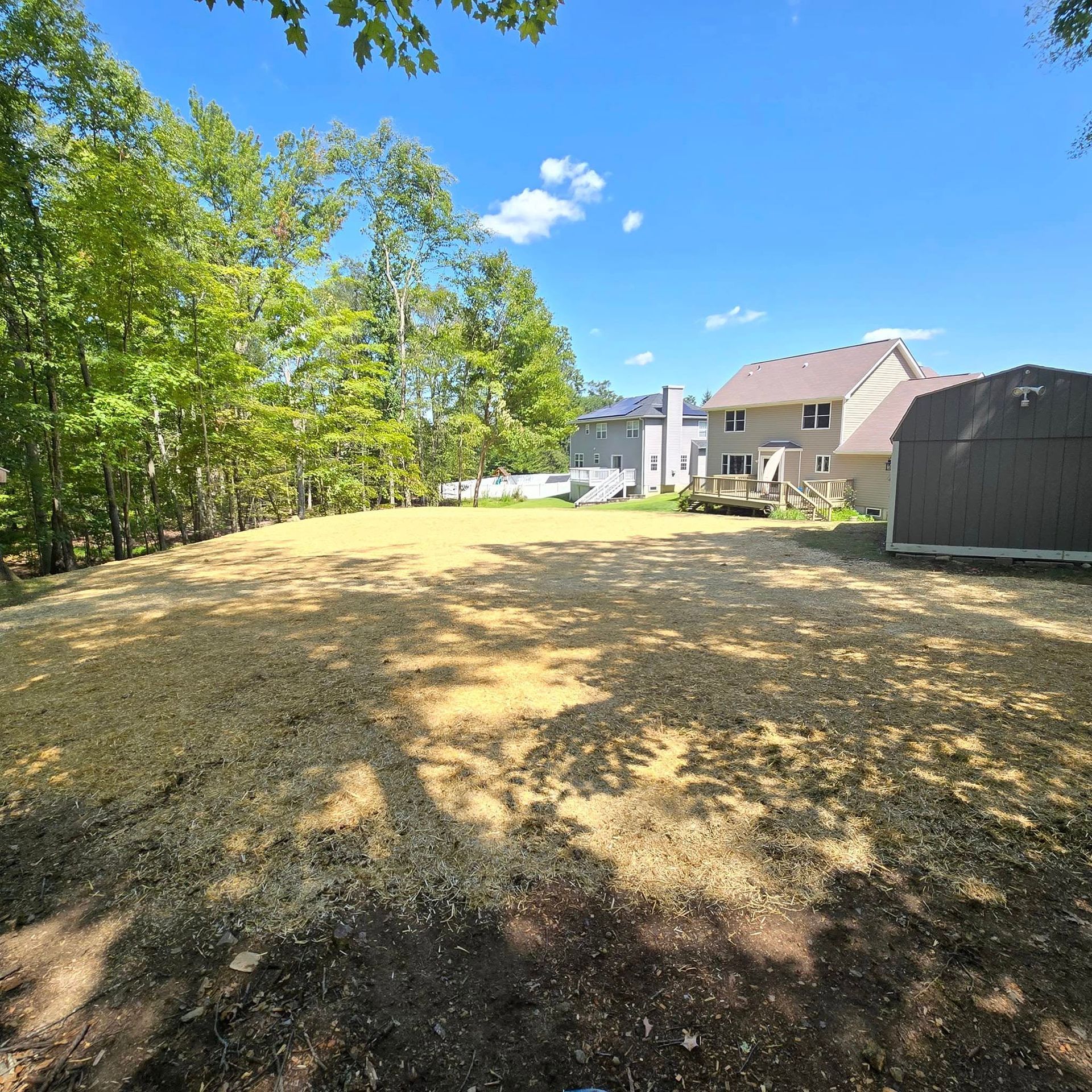 A large yard with a house in the background