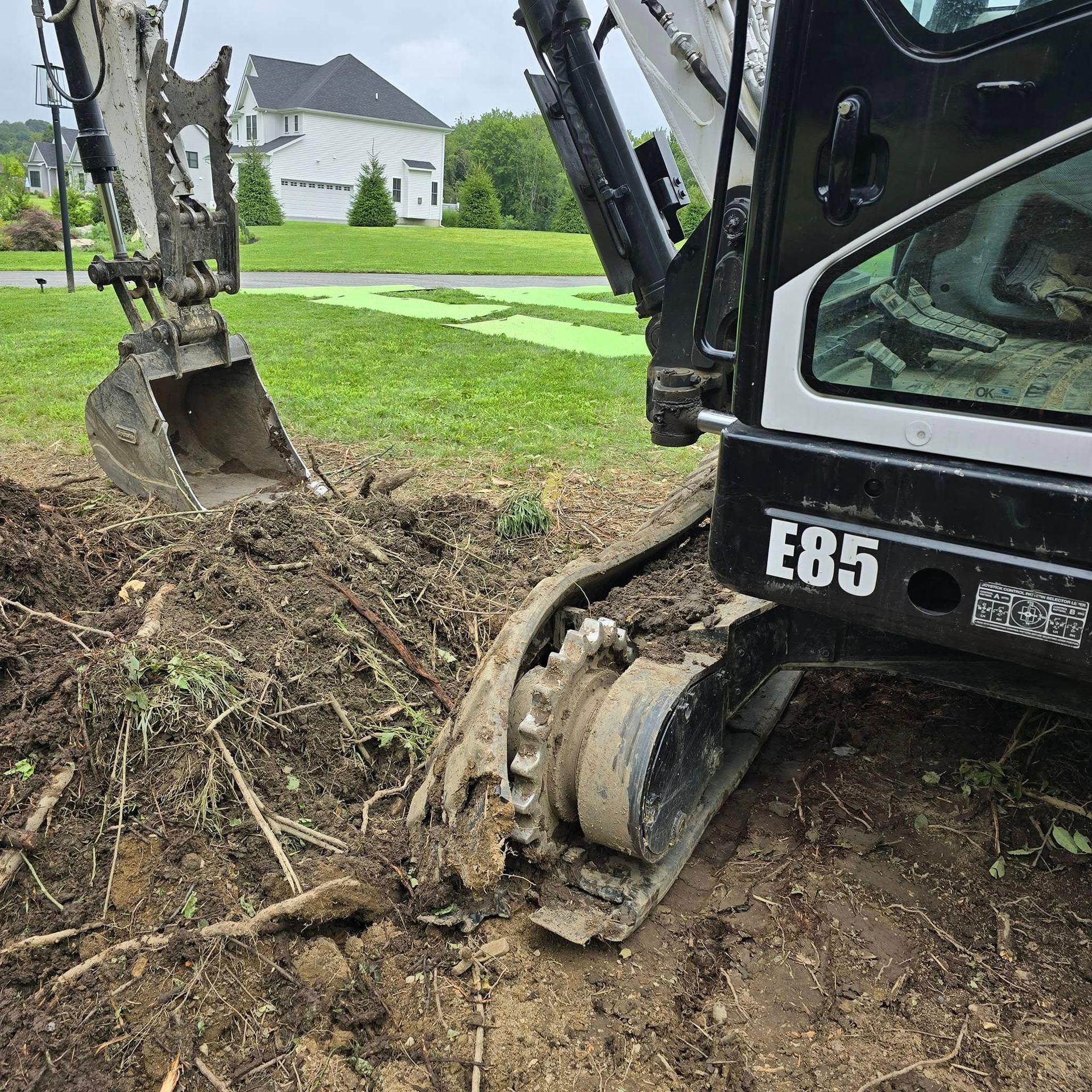 A black and white excavator is digging a hole in the ground.