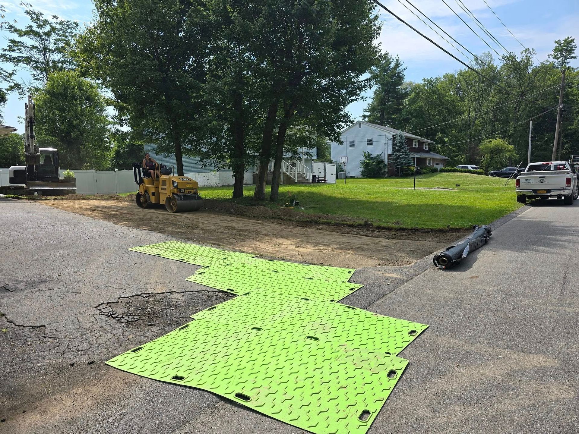 A truck is parked on the side of the road next to a green mat.