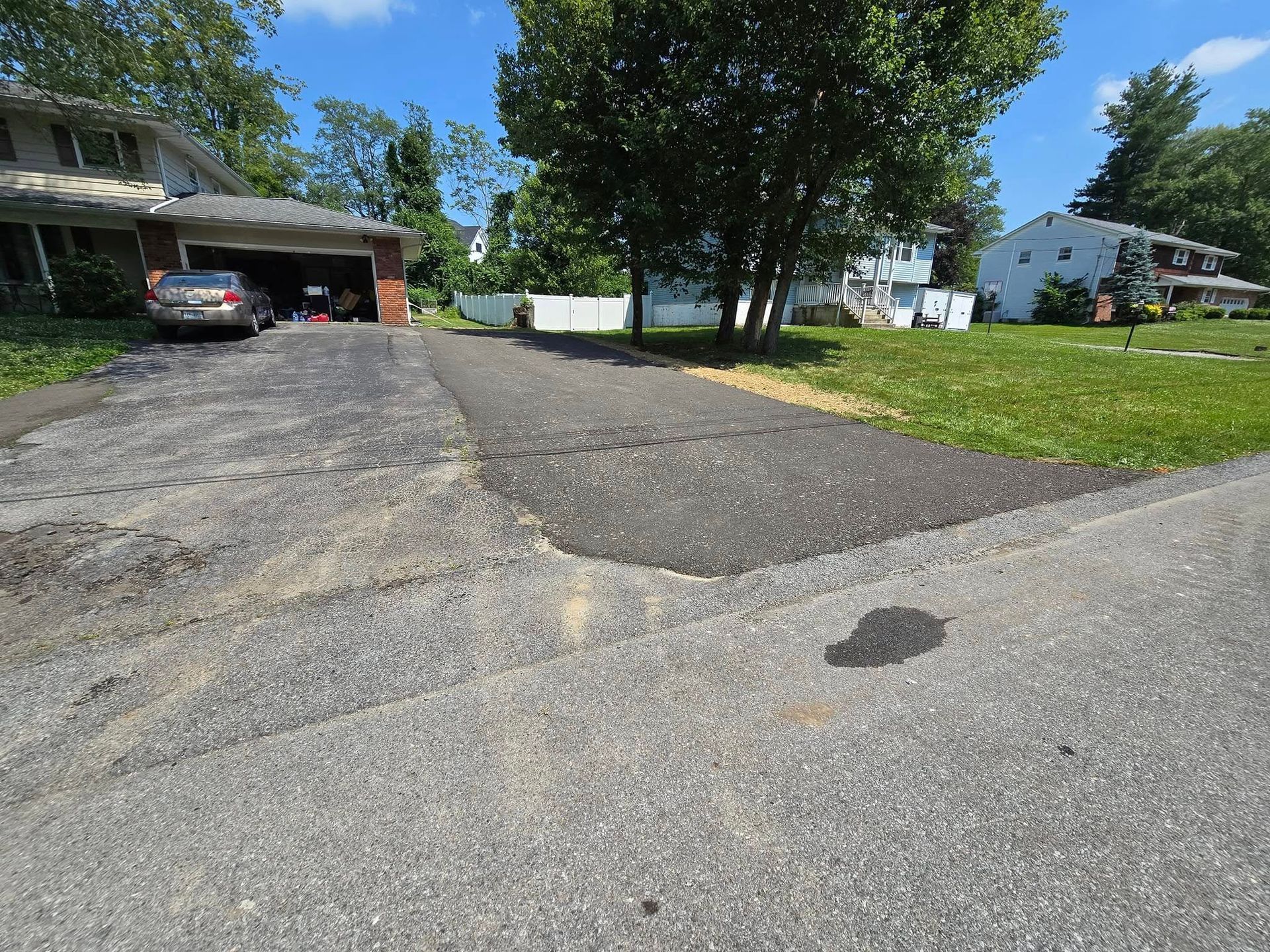 A car is parked in a driveway next to a house.