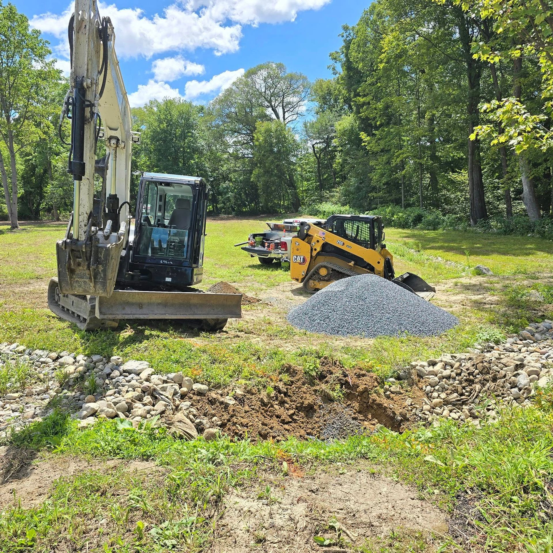 A bulldozer is digging a hole in the ground in a field.