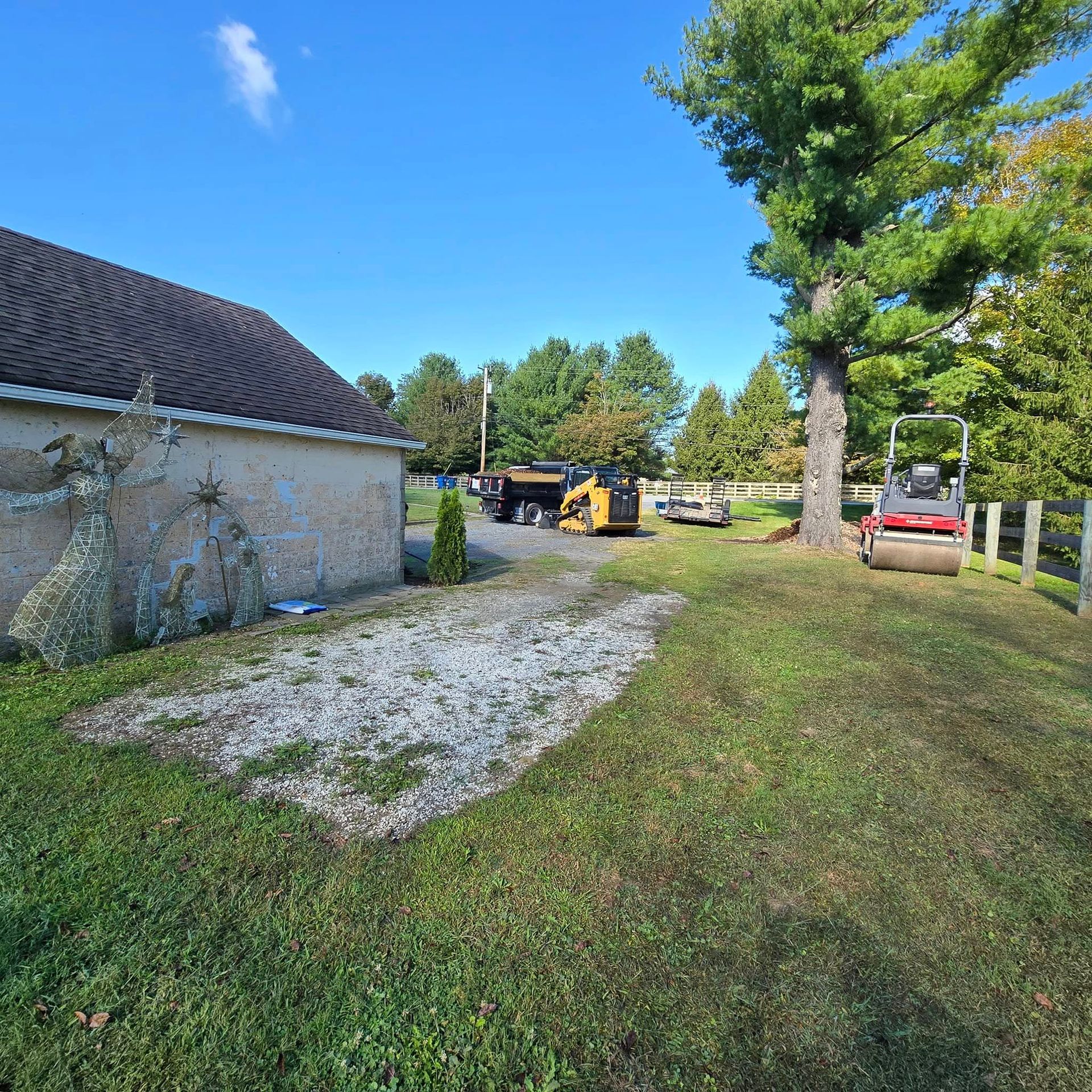 A tractor is parked in the grass in front of a house.
