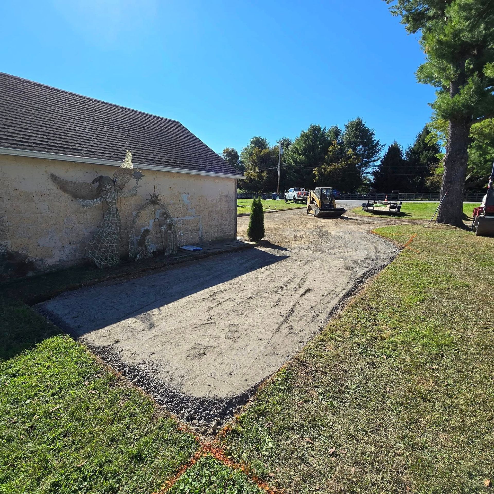 A dirt road leading to a building in a grassy area