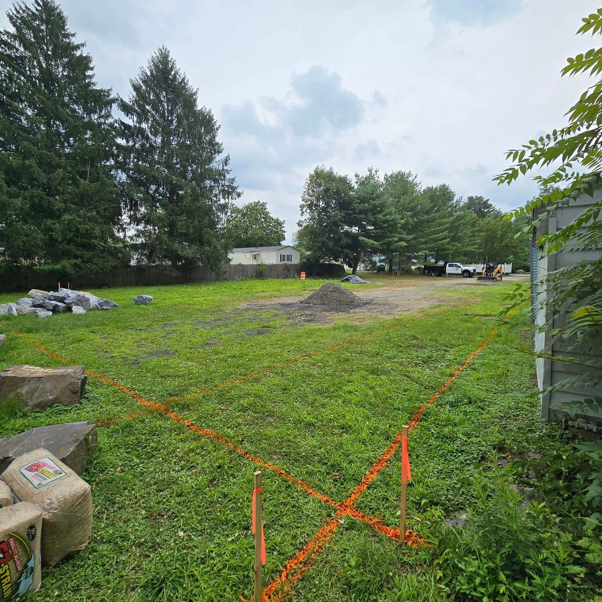 A large grassy field with a lot of trees in the background.