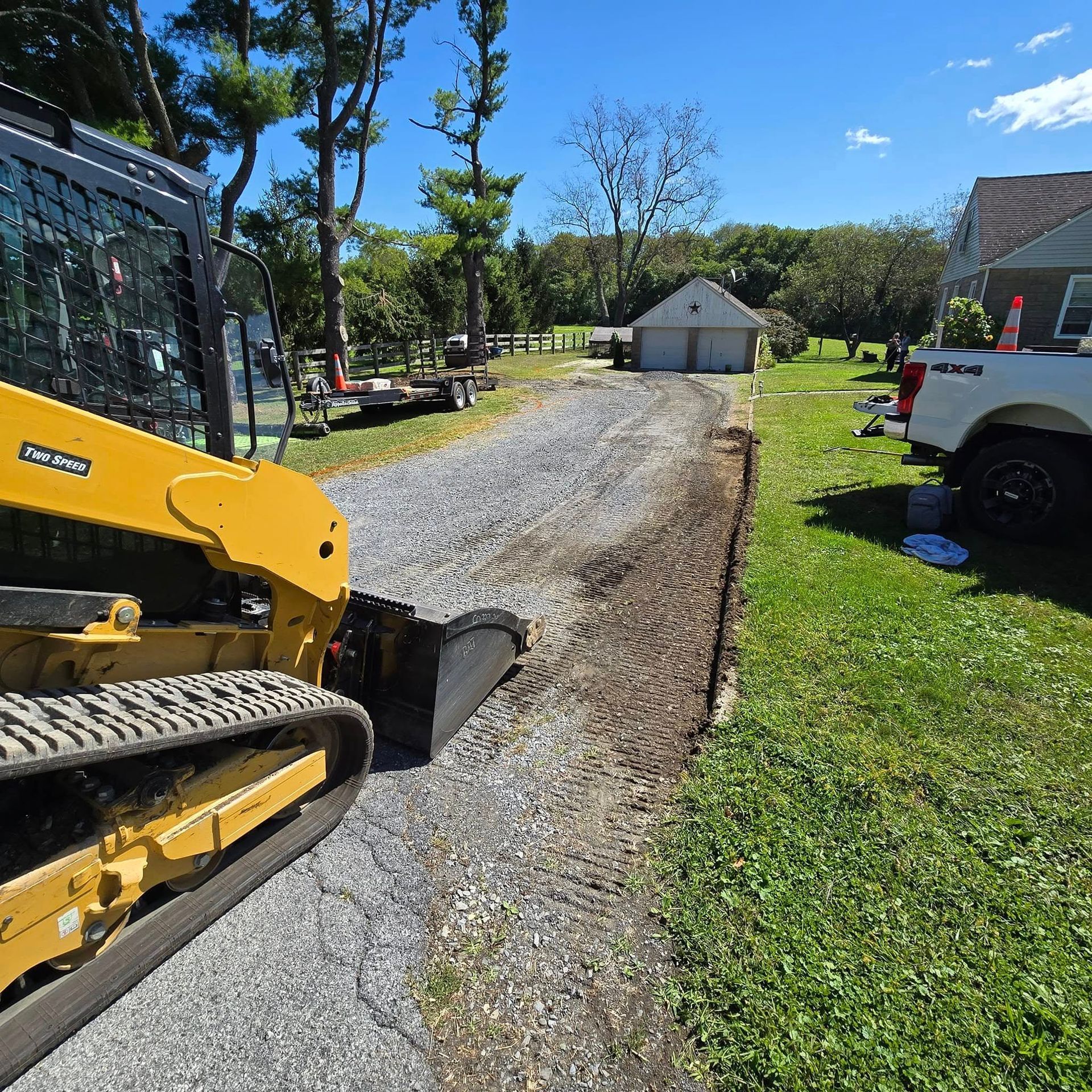 A yellow bulldozer is working on a gravel road.