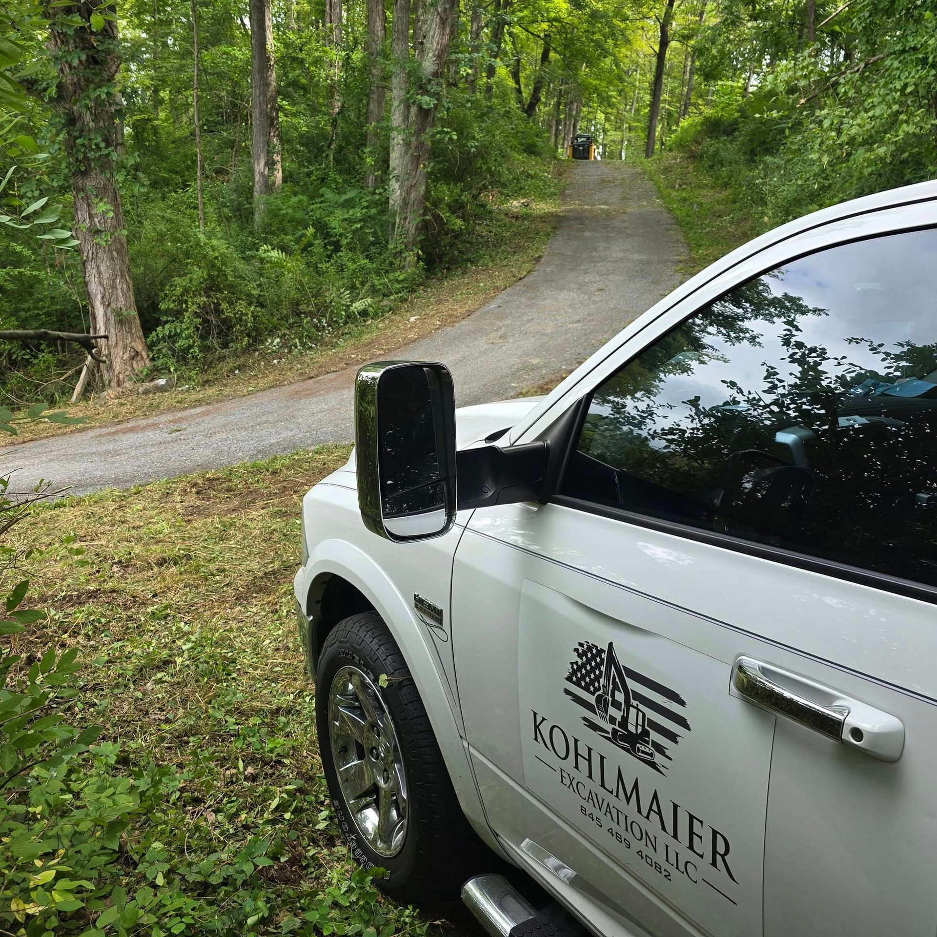 A white kohlmaier truck is parked on the side of a road