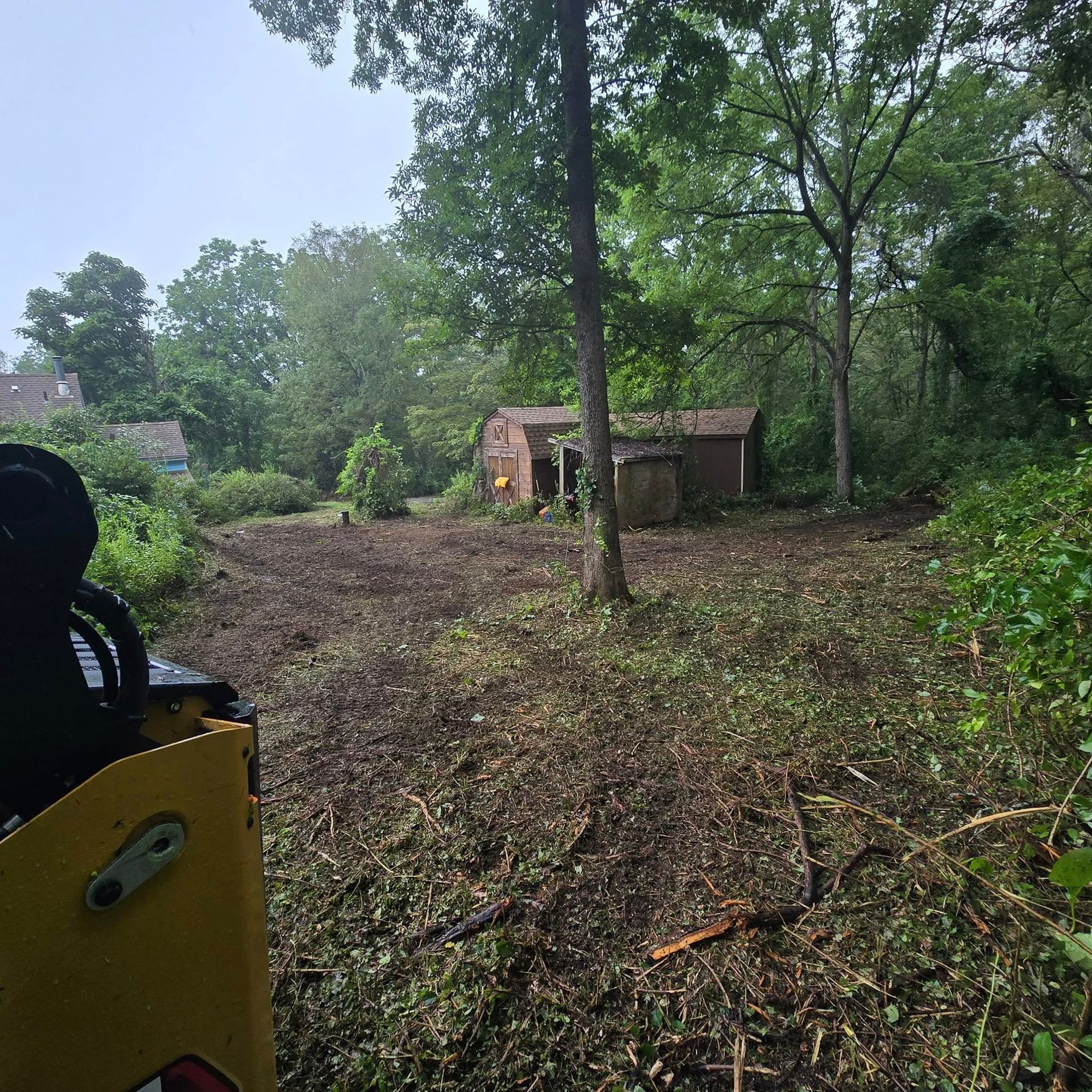 A yellow tractor is driving through a lush green field.