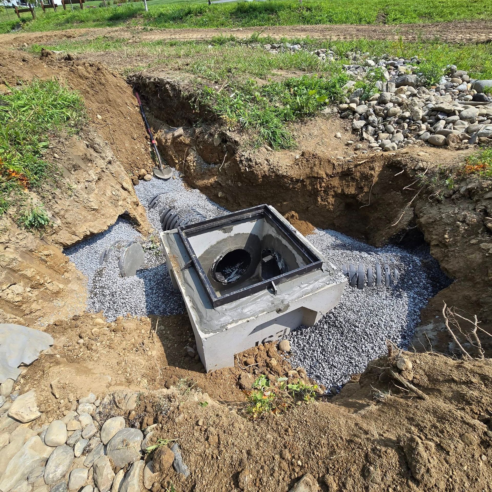 A concrete box is sitting in the middle of a dirt field.