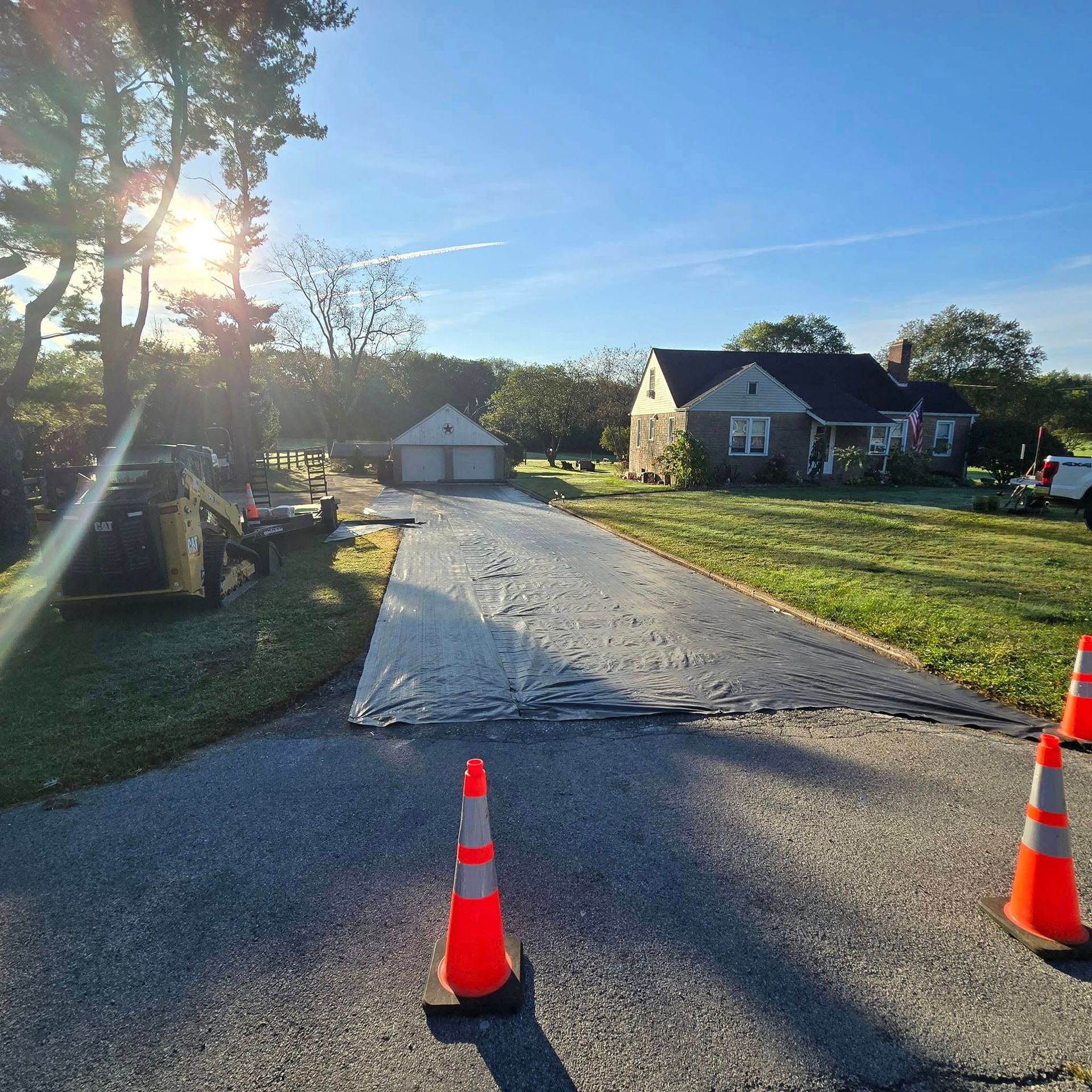 The sun is shining through the trees on the side of the road