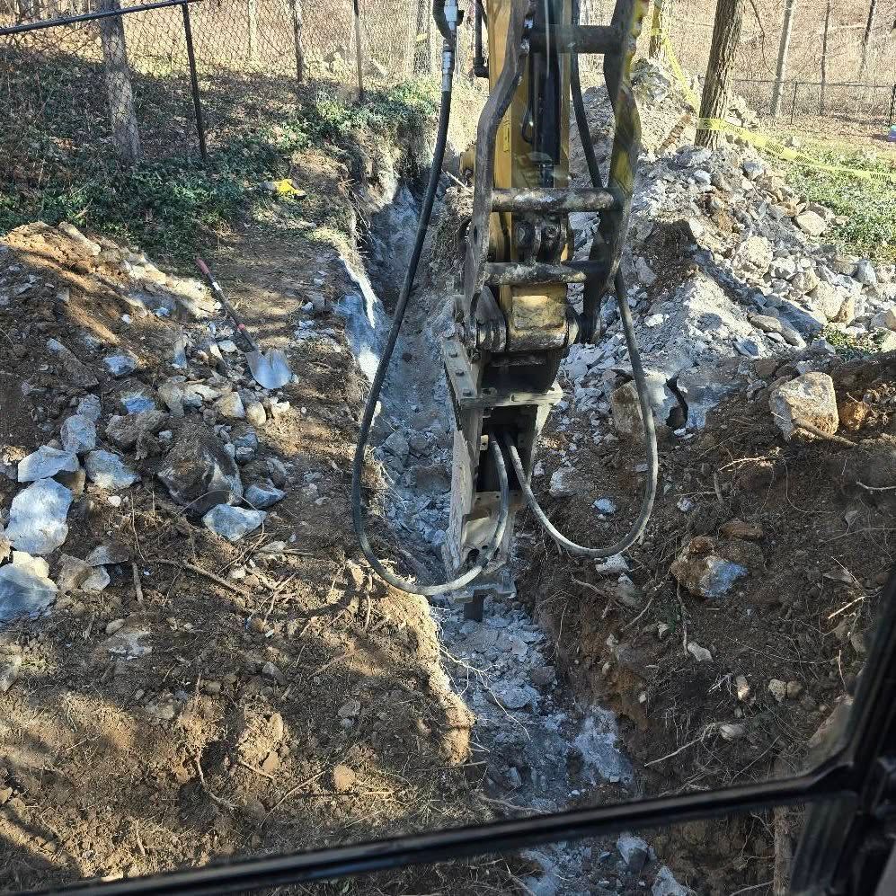A bulldozer is cutting a hole in the ground.