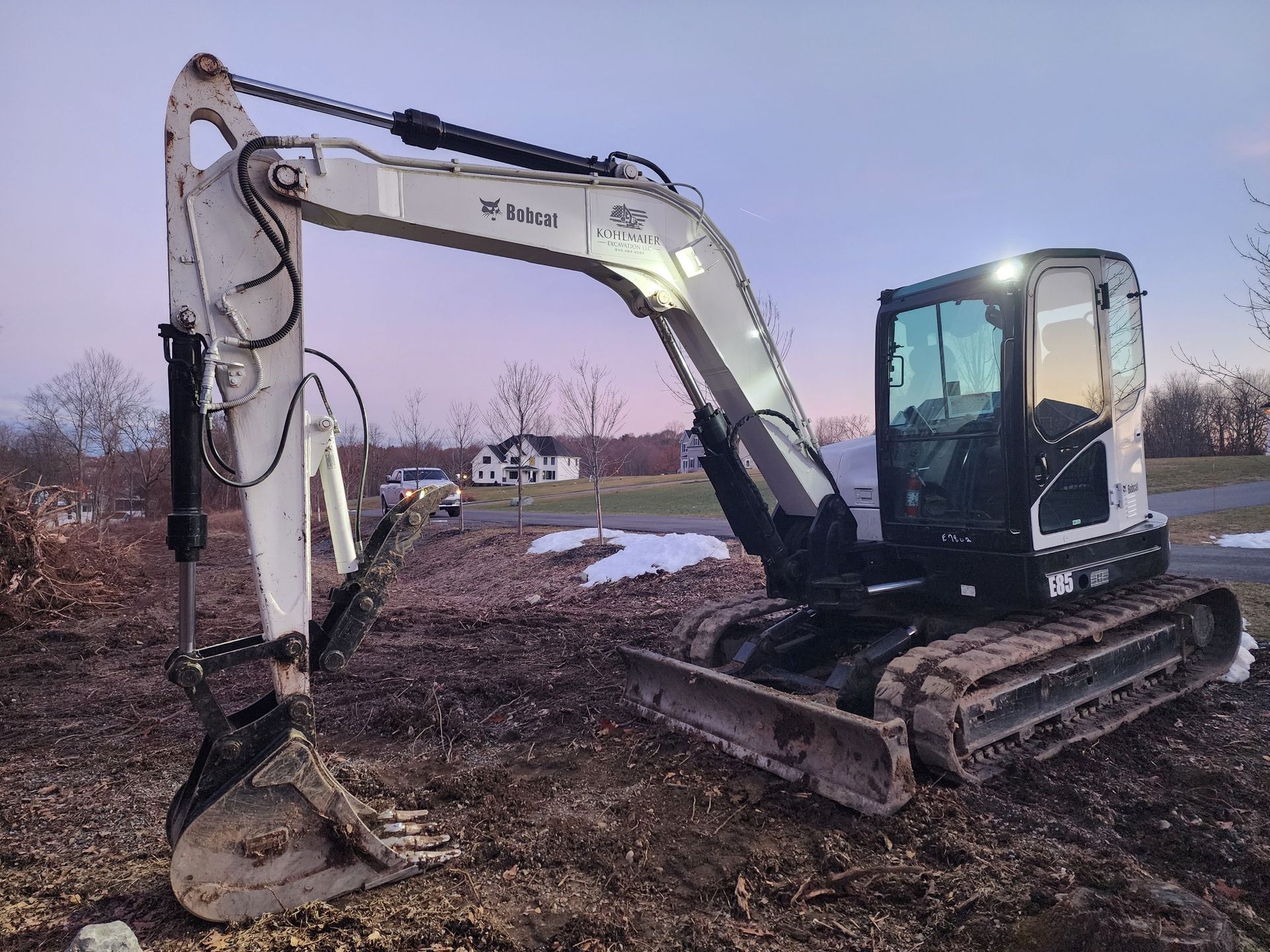 A bobcat excavator is parked in a dirt field.