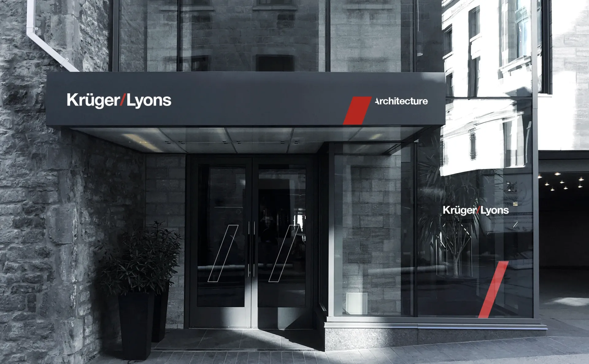 Entrance to Kruger Lyons architecture firm, with a black awning and red logo accents.