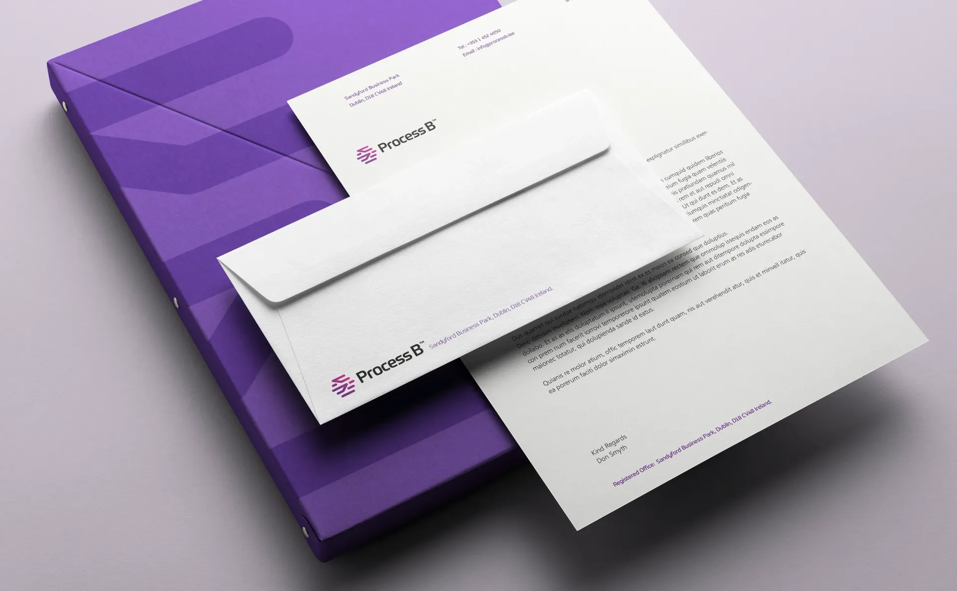 Purple corporate stationery set: letterhead, envelope, binder on light purple surface.